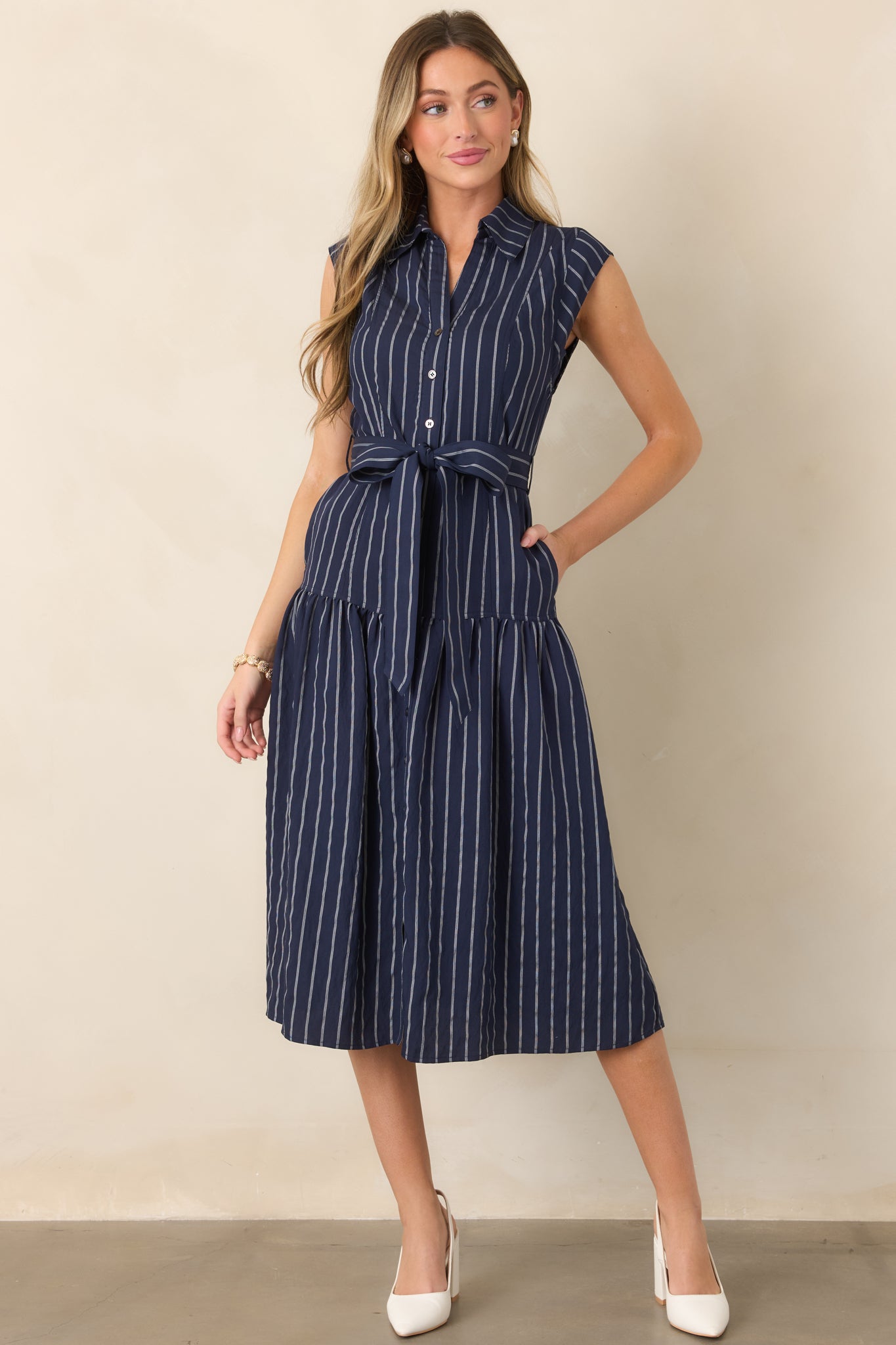 Lightweight woven midi dress featuring a collared neckline, button-front closure, removable self-tie belt, and subtle vertical stripes.