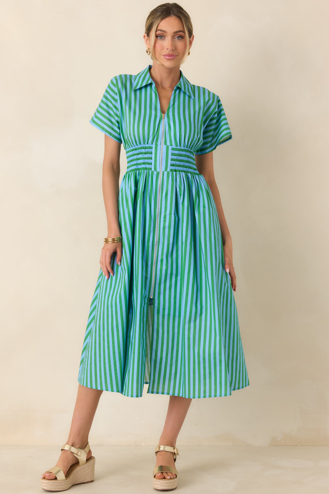 Structured collar dress featuring a fitted smocked waist and breezy A-line skirt with vibrant stripe pattern.