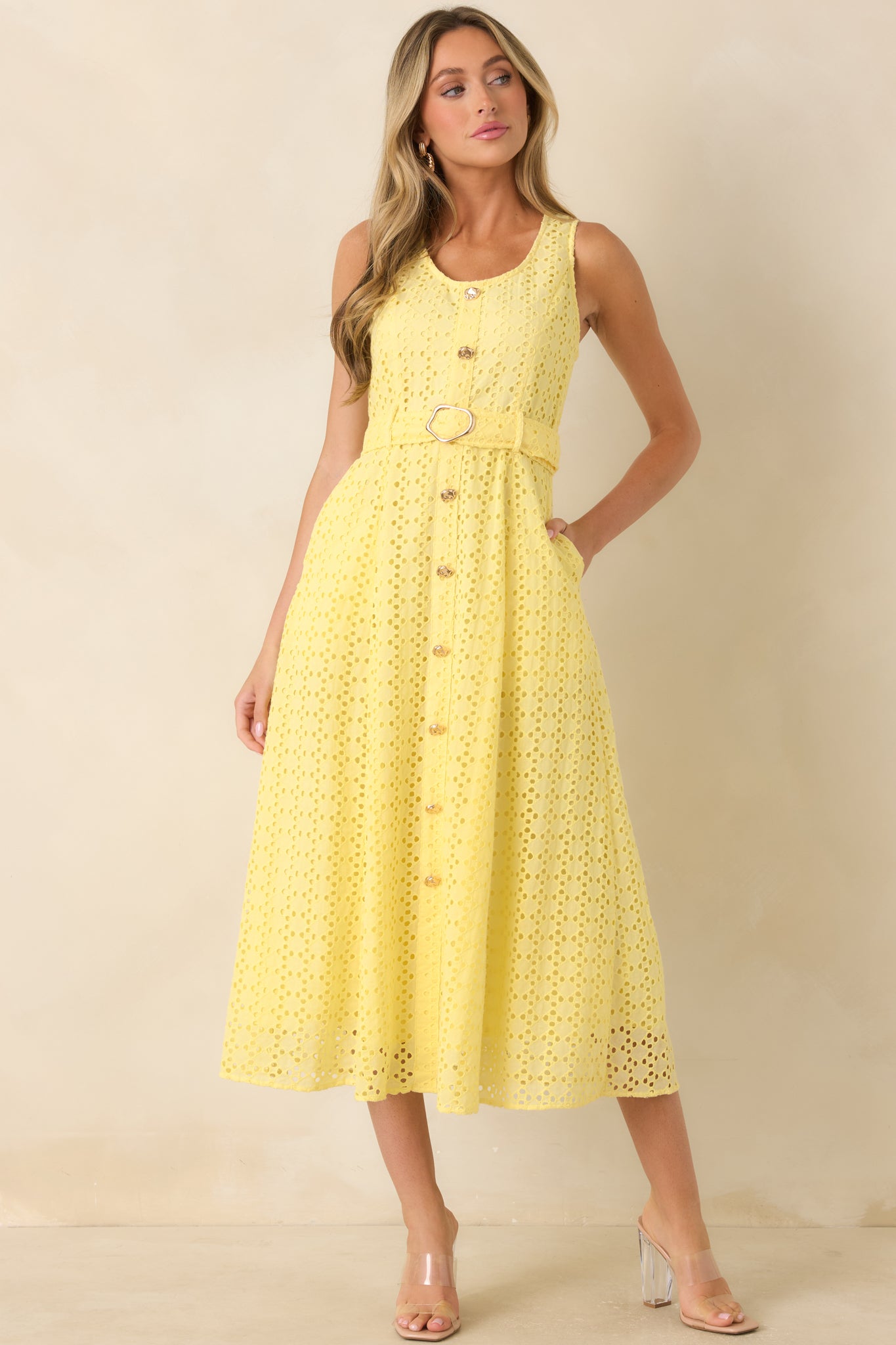 Eyelet midi dress featuring a structured silhouette, sleeveless design, and elegant waist-cinching detail.