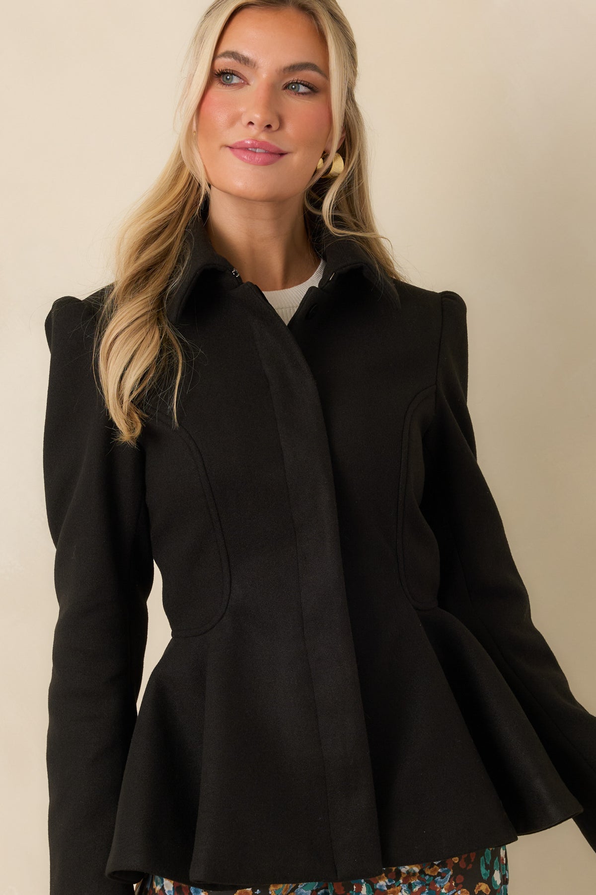 Structured felt jacket emphasizing the sculptural peplum hem and fitted waist.