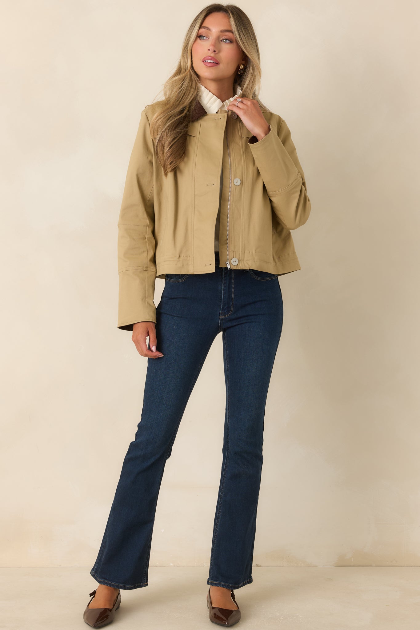 Structured khaki jacket designed with pleated chest detailing, functional side pockets, and a contrasting brown corduroy collar.