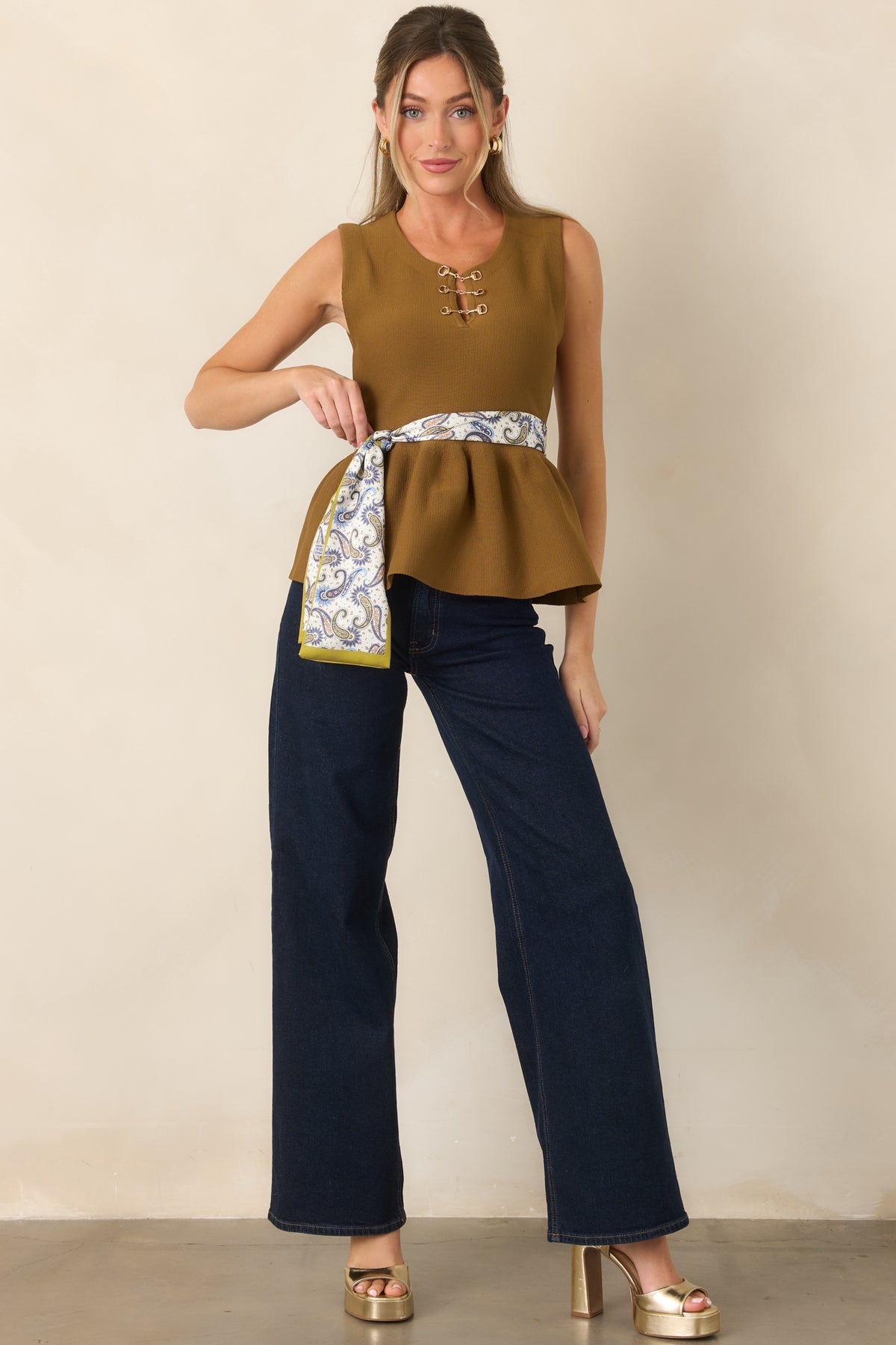 Structured knit peplum top finished with refined gold-tone neckline hardware.