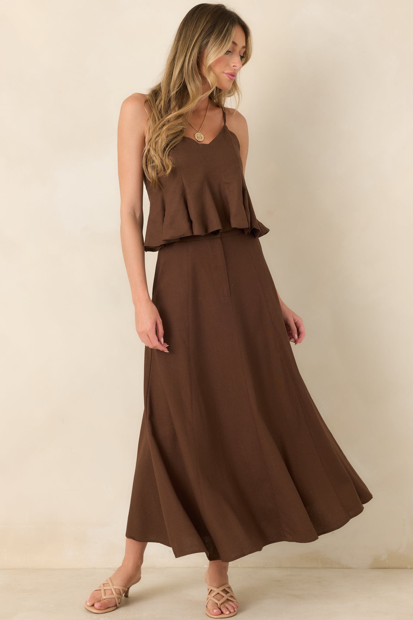 Structured linen and cotton skirt showcasing a high-rise waistband, button detail, paneled seams, practical pockets, and an elegant draped silhouette.