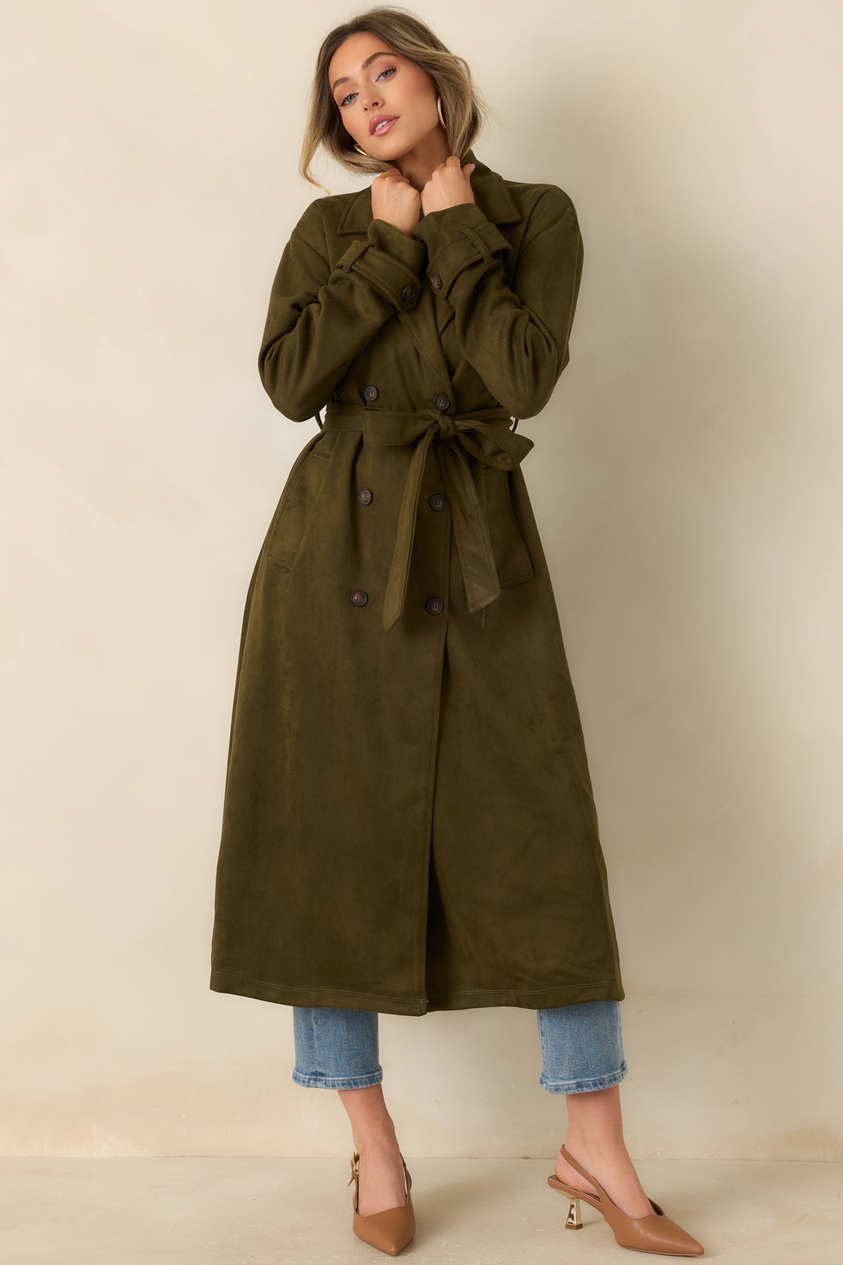Structured long coat featuring a double-button front, matching waist tie, and side pockets.