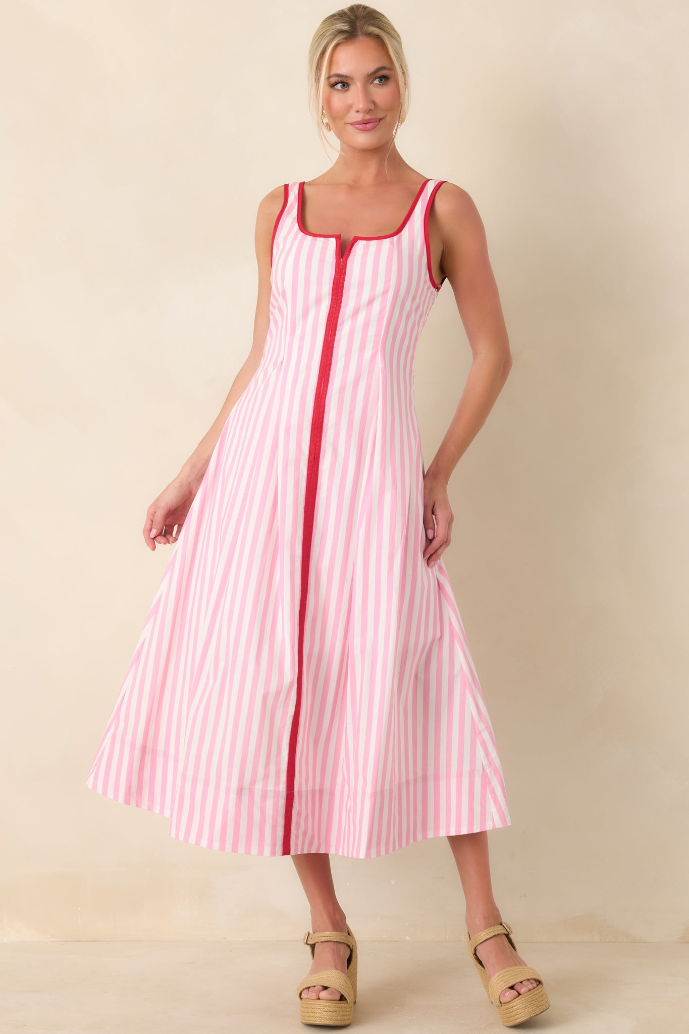 Structured pink and white striped dress combining comfort with a flared midi-length skirt.