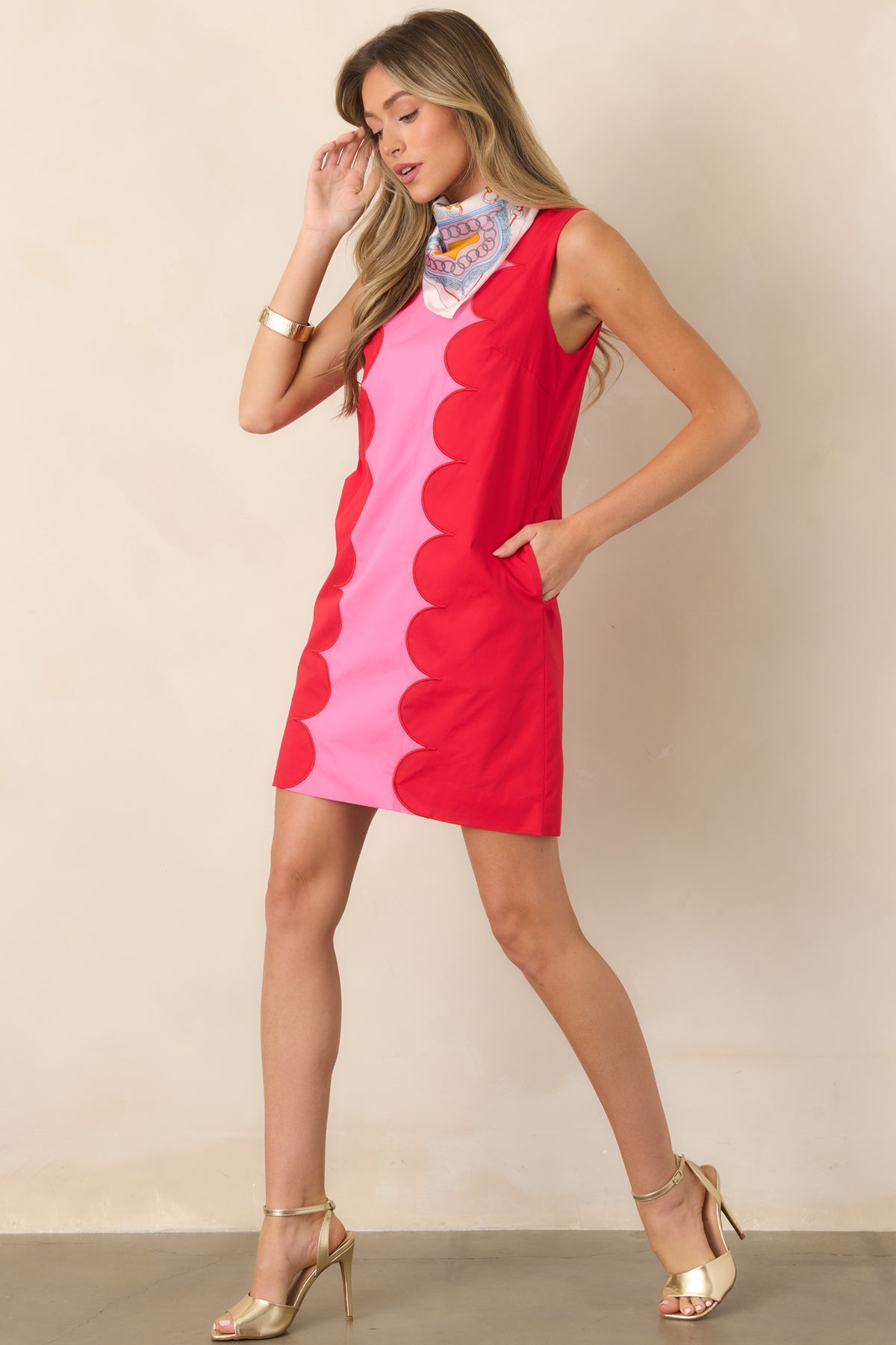 Structured pink mini dress highlighted by contrasting red scalloped borders and a clean sleeveless design with hidden side pockets.