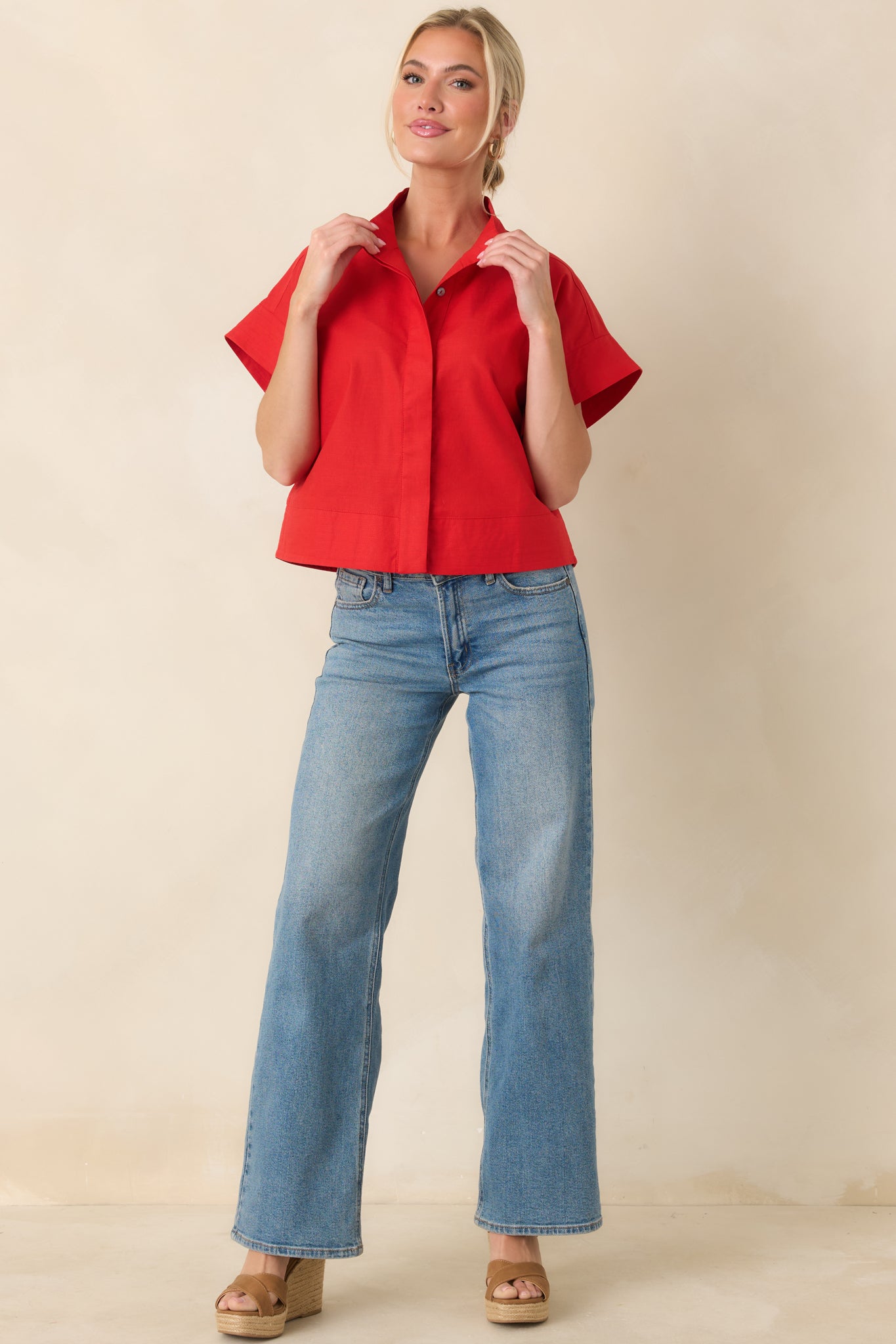 Structured red top with short sleeves, mock neckline, and slightly relaxed yet polished fit.