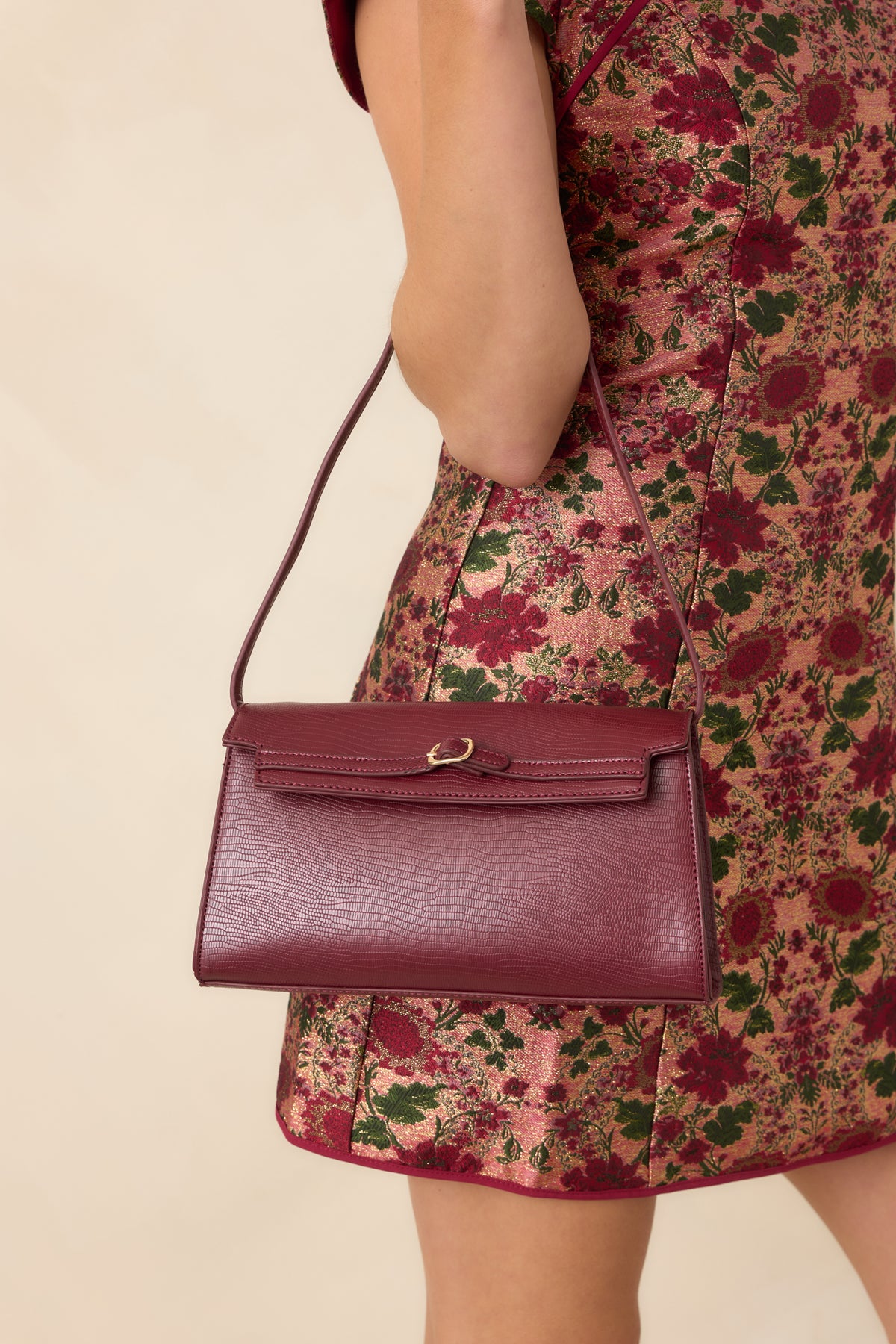 Structured handbag showcases crisp geometric lines, a fine-scale textured finish, and a slim strap designed for underarm or hand carry.