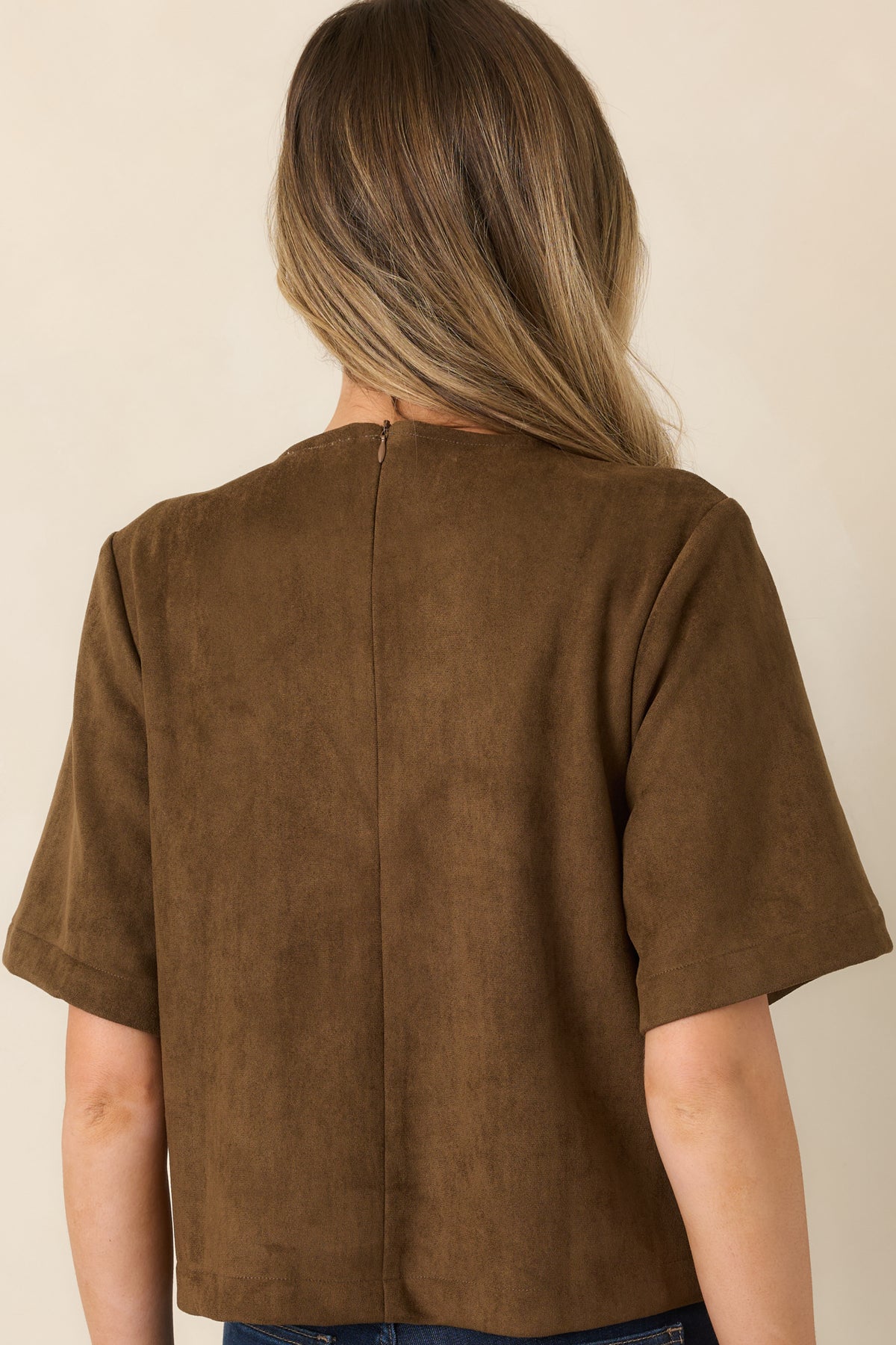 Rear view of the suede-like top showcasing its relaxed boxy silhouette, round neckline, and short sleeves.