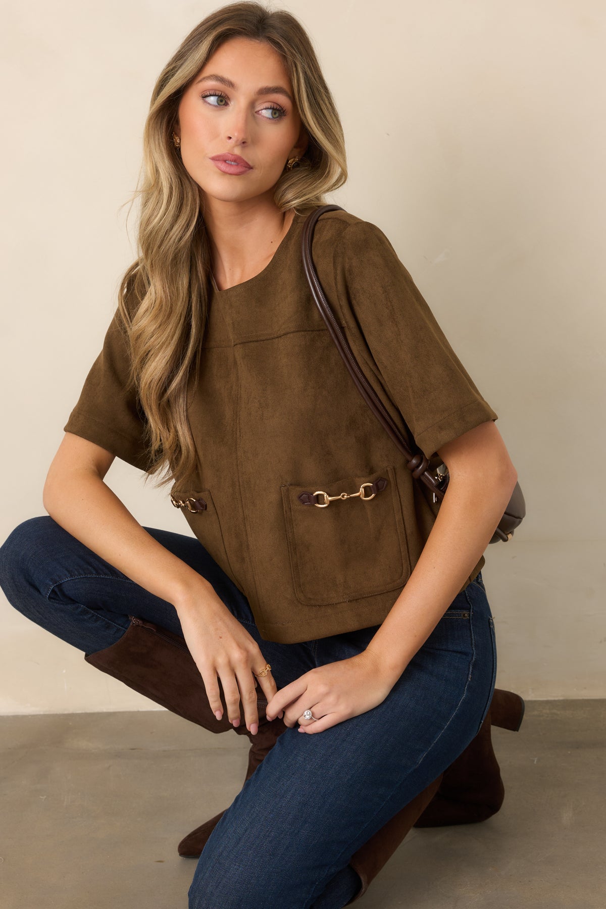Suede-like top highlighting the oversized patch pockets and decorative horsebit-inspired hardware across the front.
