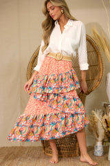 Full body view of  this skirt that features an elastic waistband, tiered ruffles, colorful prints, and an asymmetrical hem.
