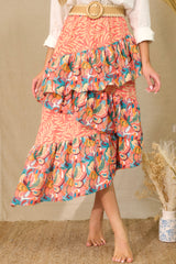Front view of  this skirt that features an elastic waistband, tiered ruffles, colorful prints, and an asymmetrical hem.