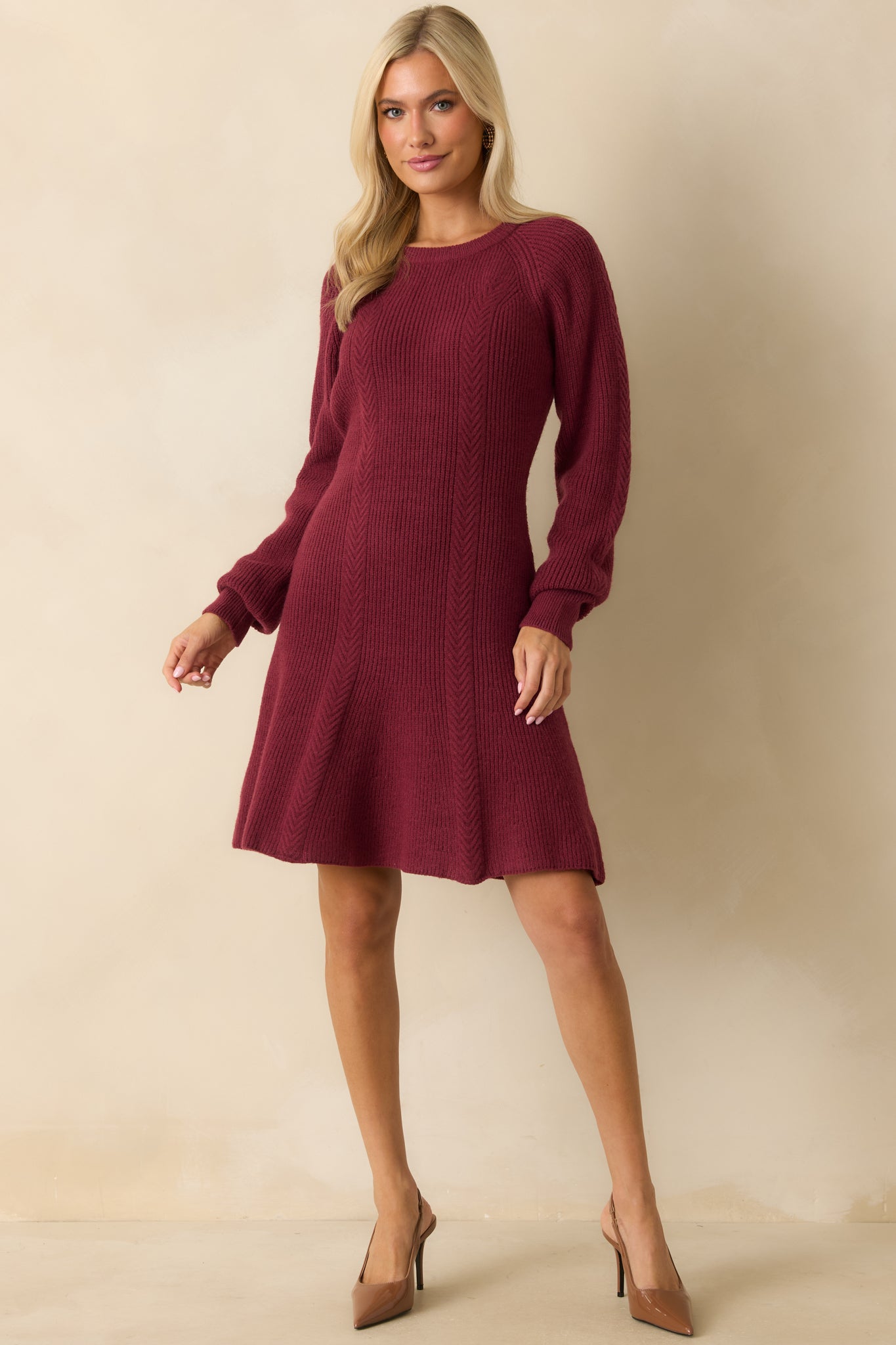 Soft burgundy sweater dress featuring a fitted silhouette, ribbed texture, and gently flared hem for a feminine shape.