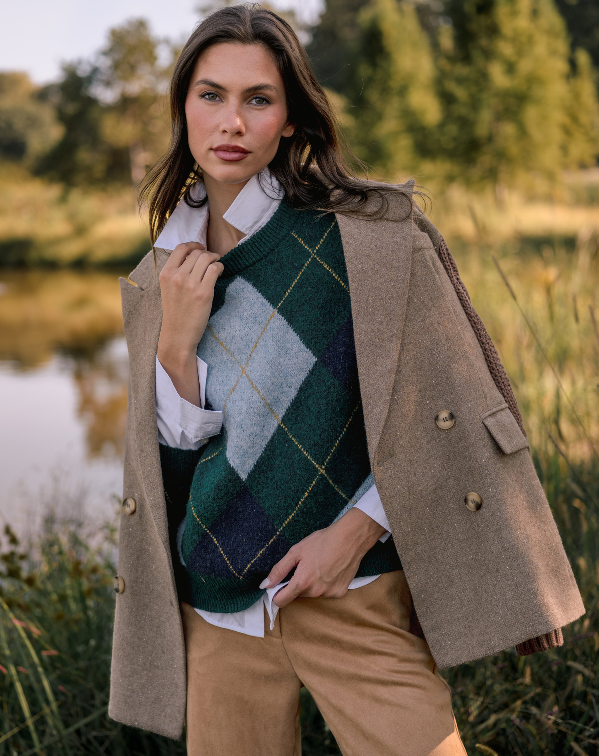 Model wearing a green argyle sweater with a tan blazer.
