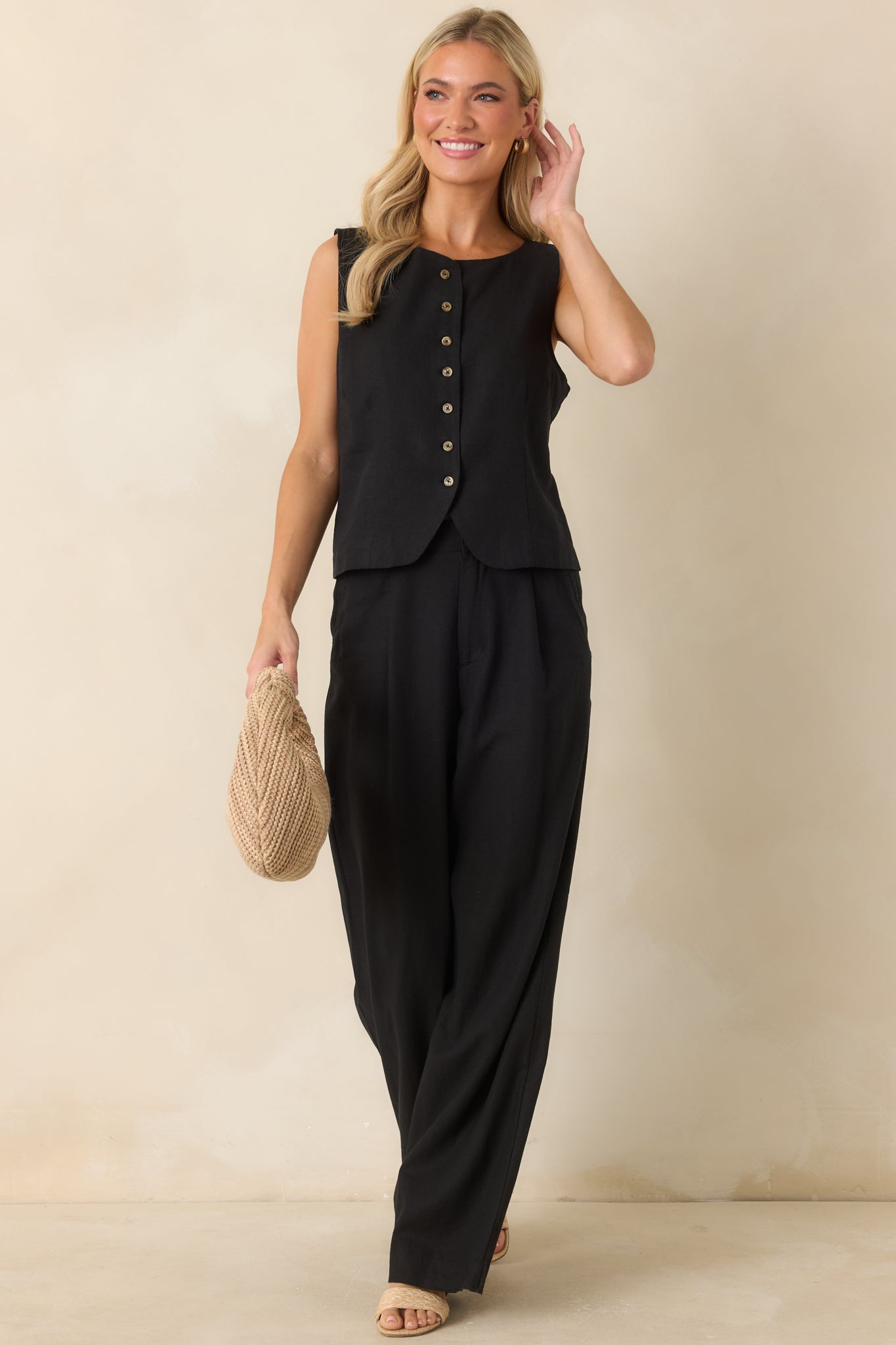 Lightweight black vest designed with a rounded neckline, tailored seam detailing, and tortoise-inspired buttons for a polished finish.