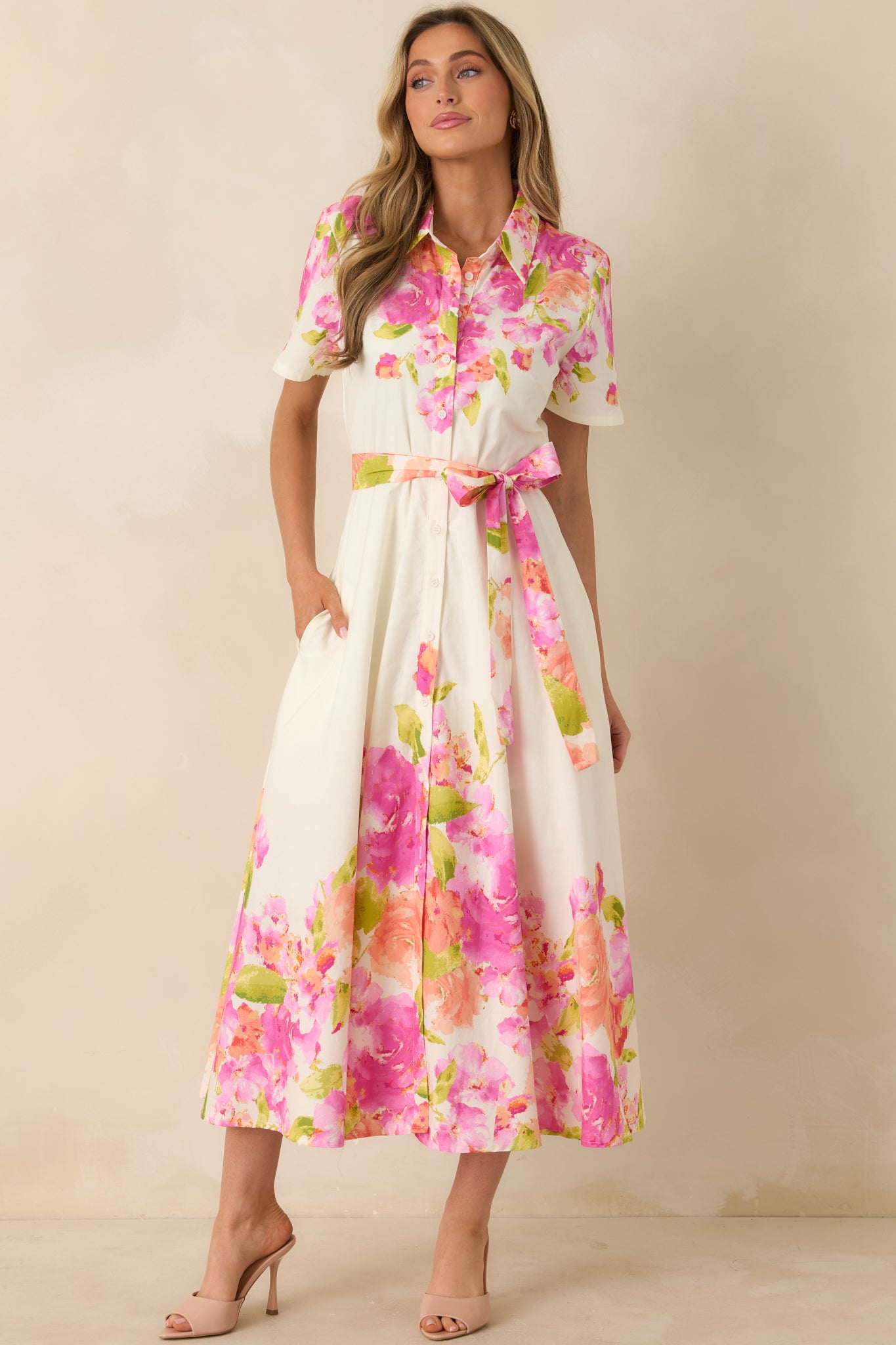 Tailored bodice flowing into full skirt with removable self-tie belt and vibrant floral hem.