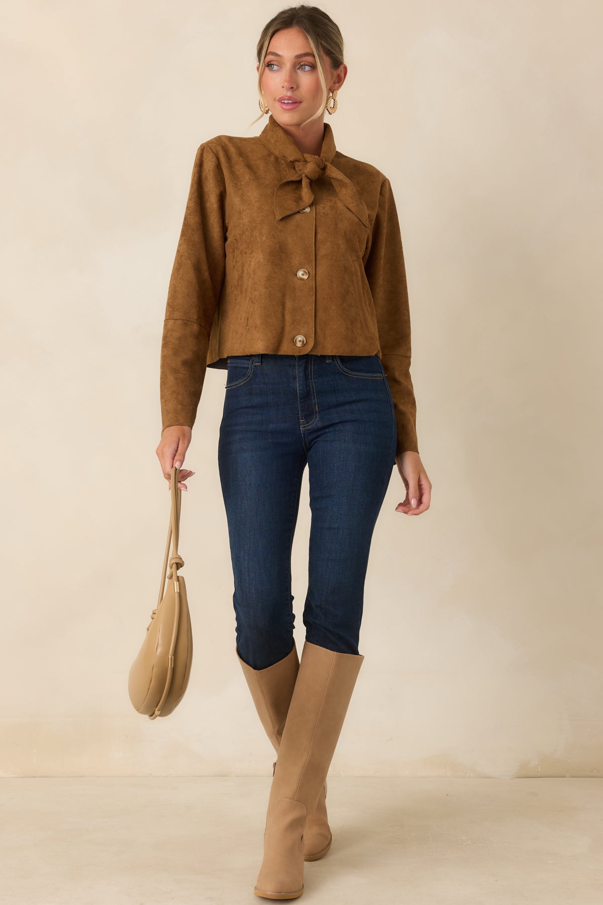 Tailored cropped jacket in soft camel faux suede, designed with a feminine neckline tie, polished buttons, welt pockets, and a relaxed structured shape.