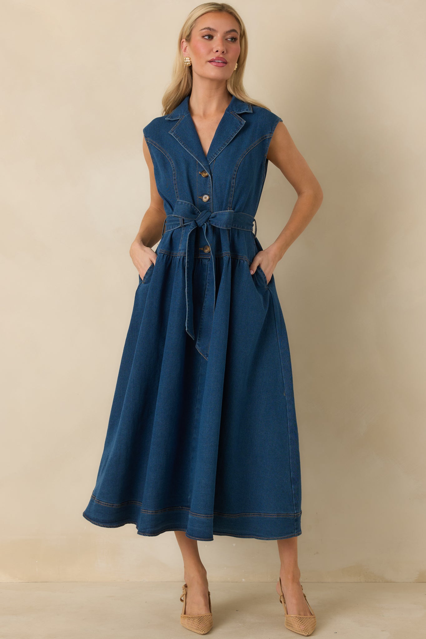 Tailored denim dress featuring a removable self-tie belt, structured seams, and side pockets for functionality.