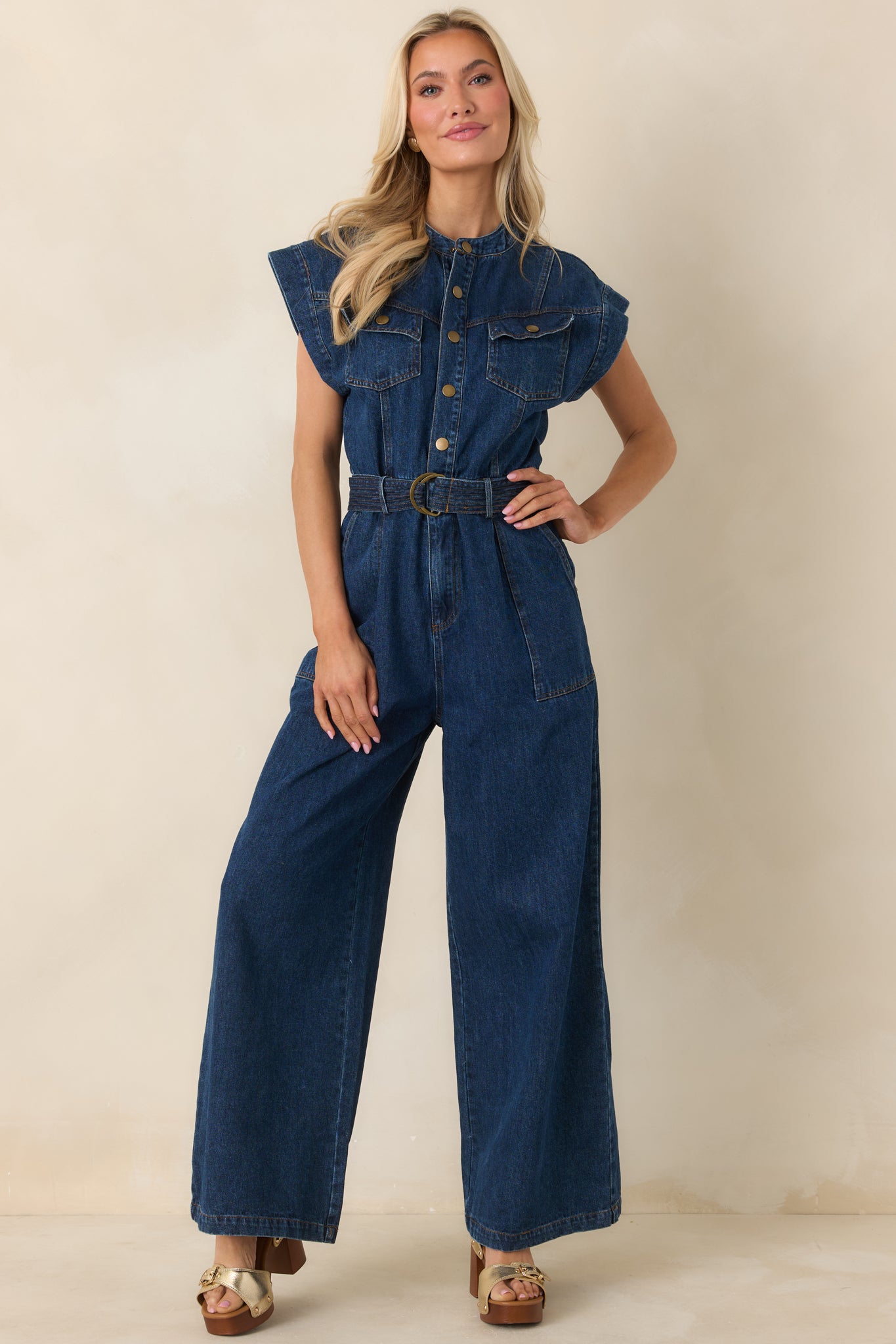 Tailored jumpsuit showcasing snap-button closure, utility pockets, and fluid wide-leg drape.