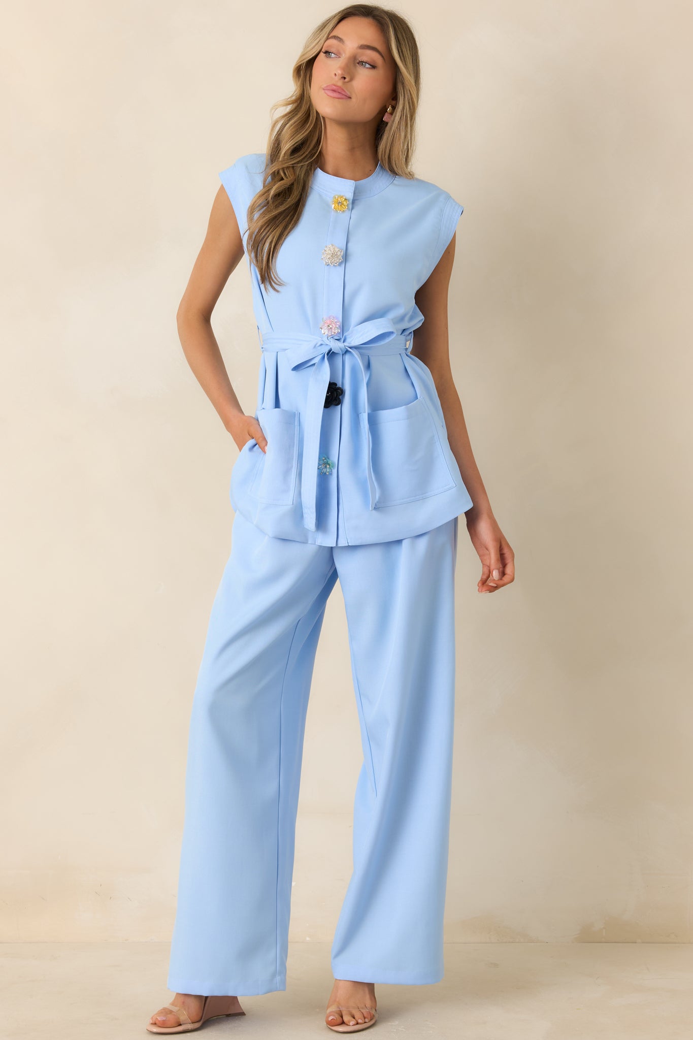 Tailored light blue top with waist tie and delicate jewelry-style button accents