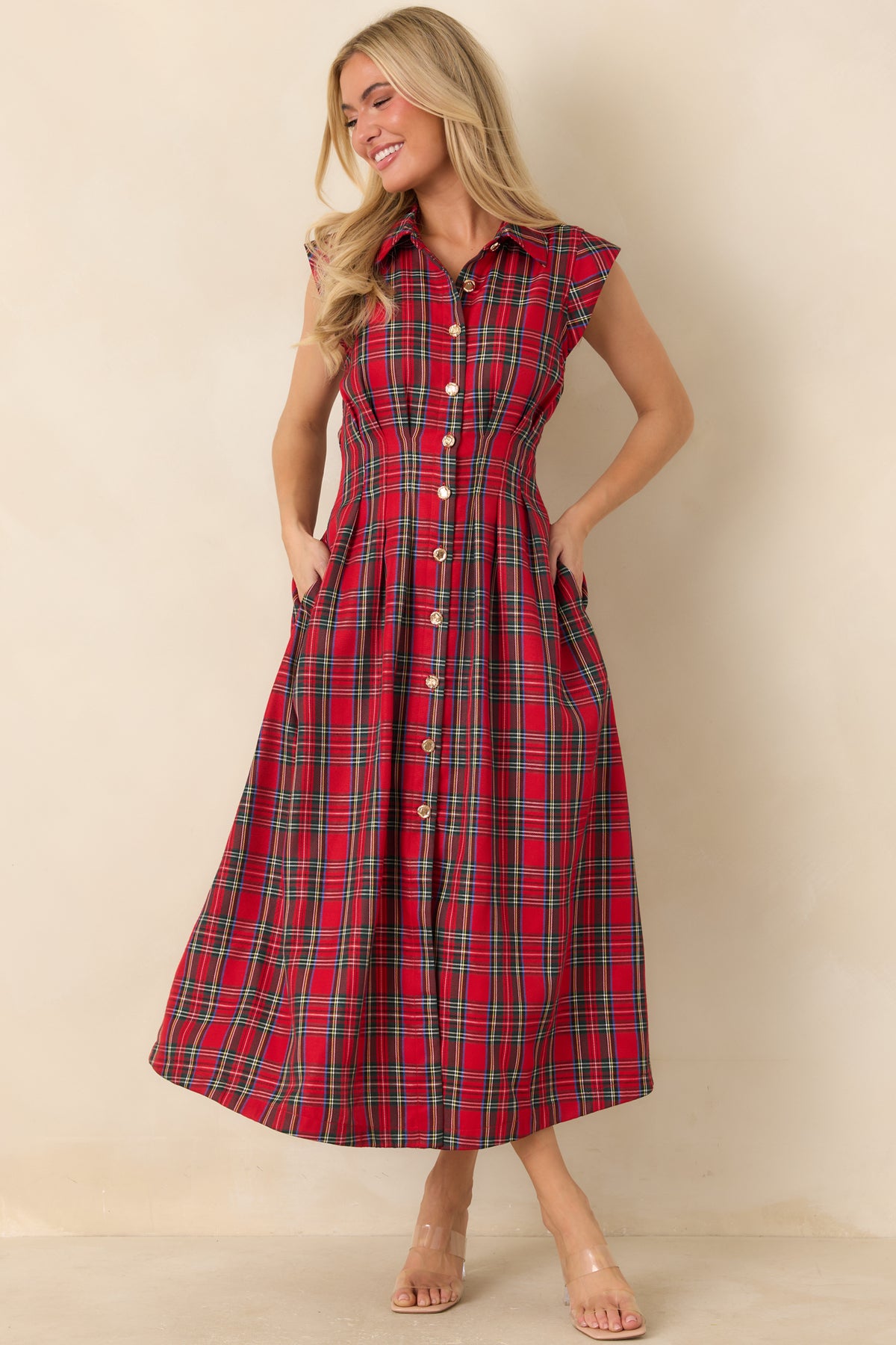 Tailored dress featuring a fitted bodice, defined waist seams, and a flowing pleated midi skirt.