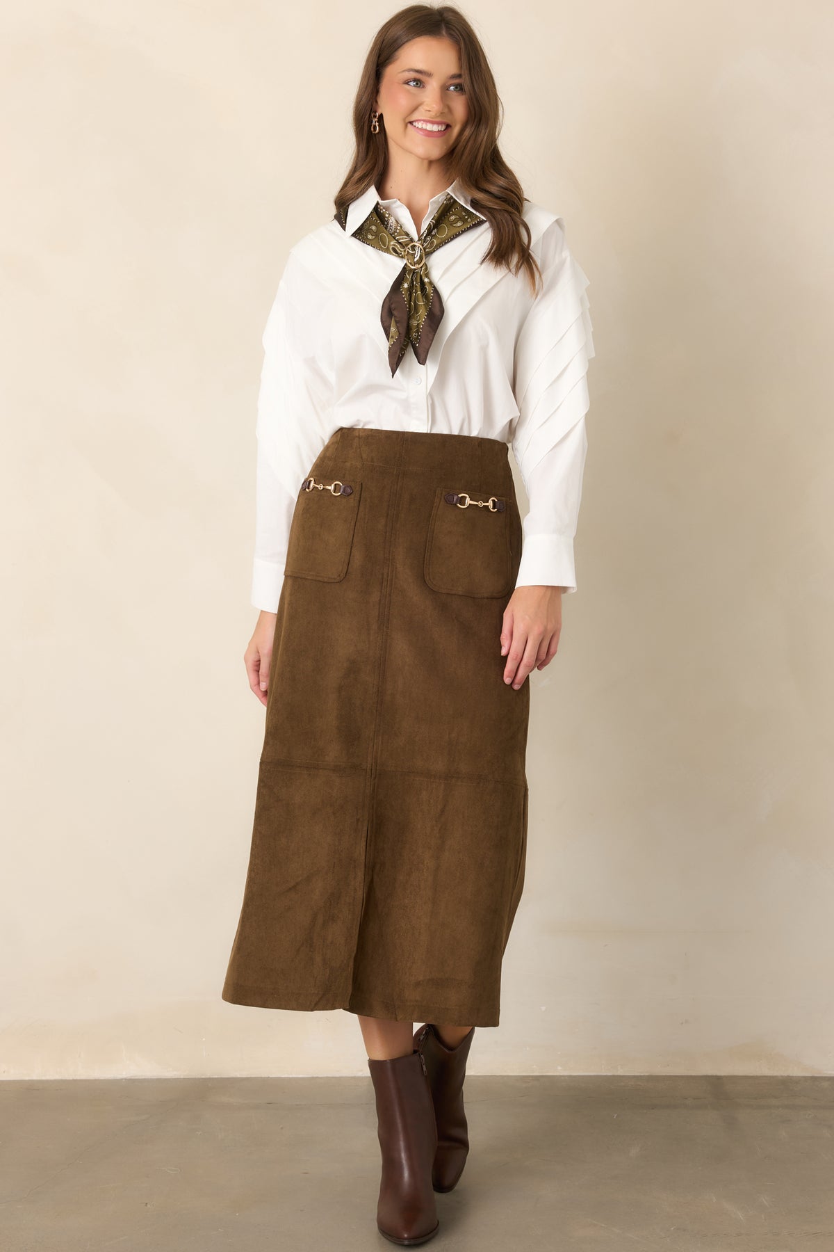 Tailored midi skirt featuring a high-rise waist, front patch pockets, and gold-tone horse-tack hardware.