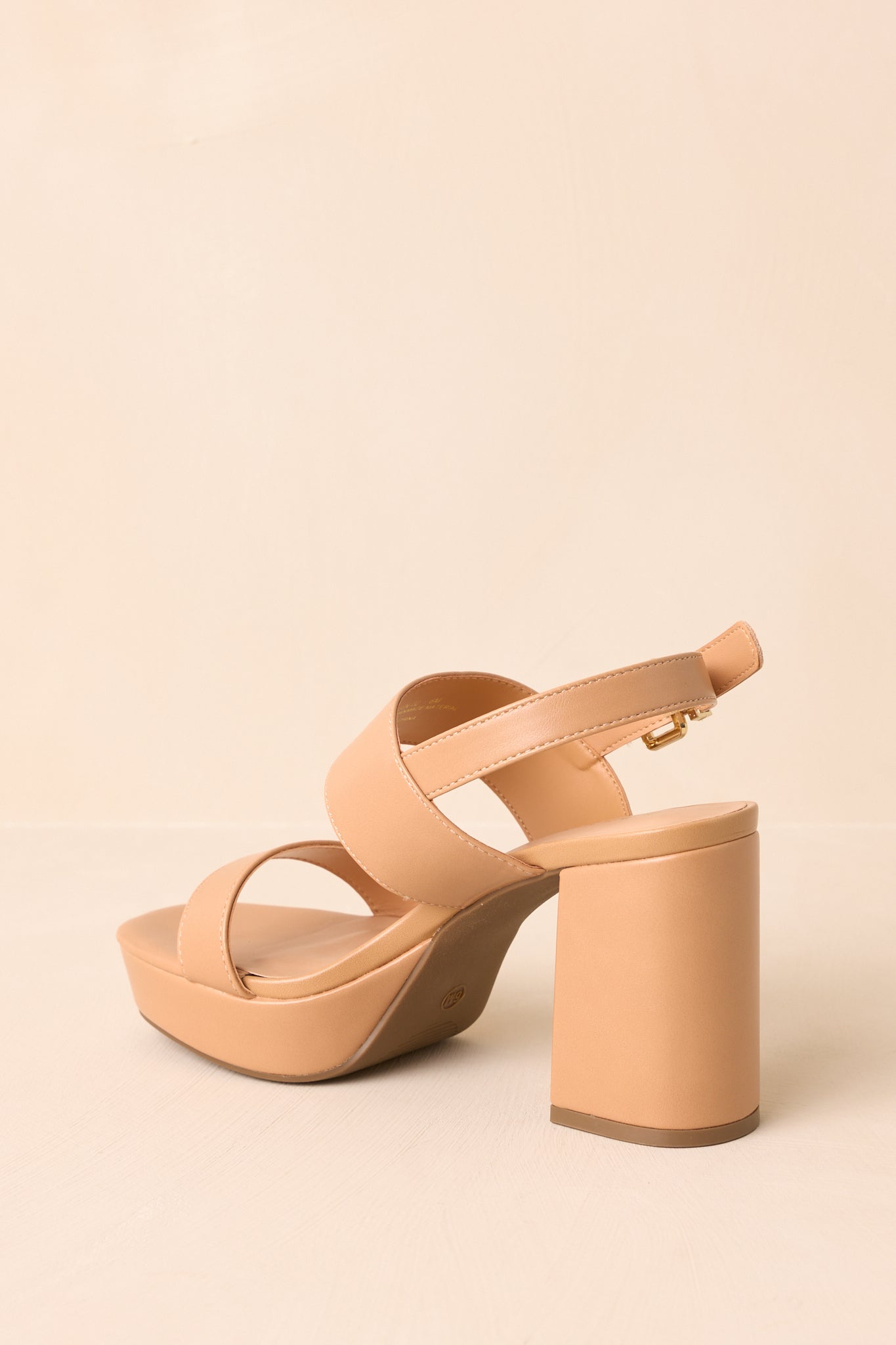 Rear view of the tan block heel sandals highlighting the back ankle strap and heel shape.