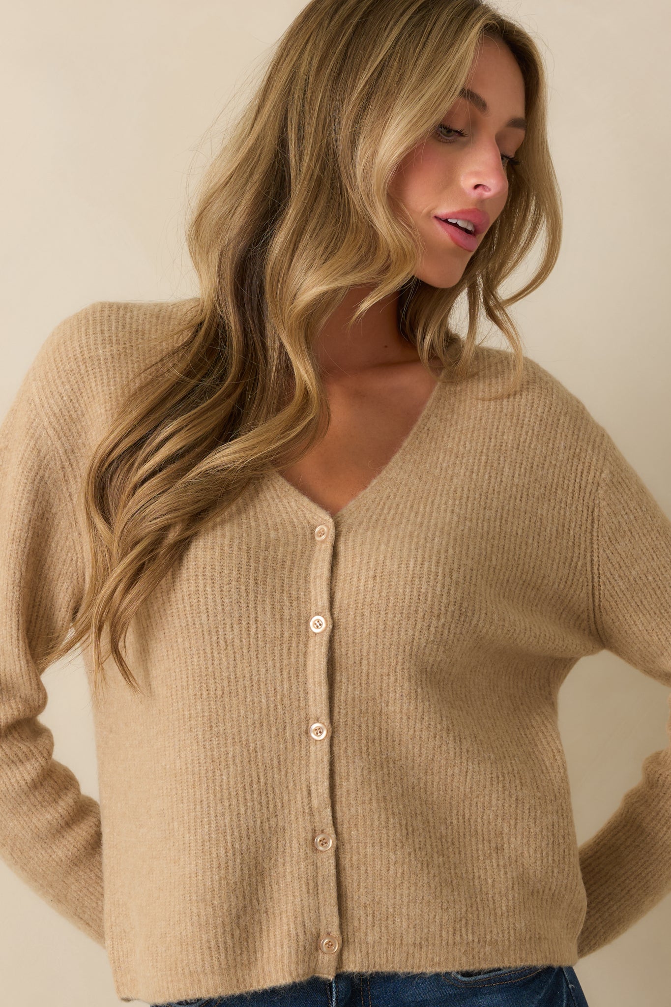 Long sleeves and soft knit highlighting the relaxed fit of the tan cardigan.