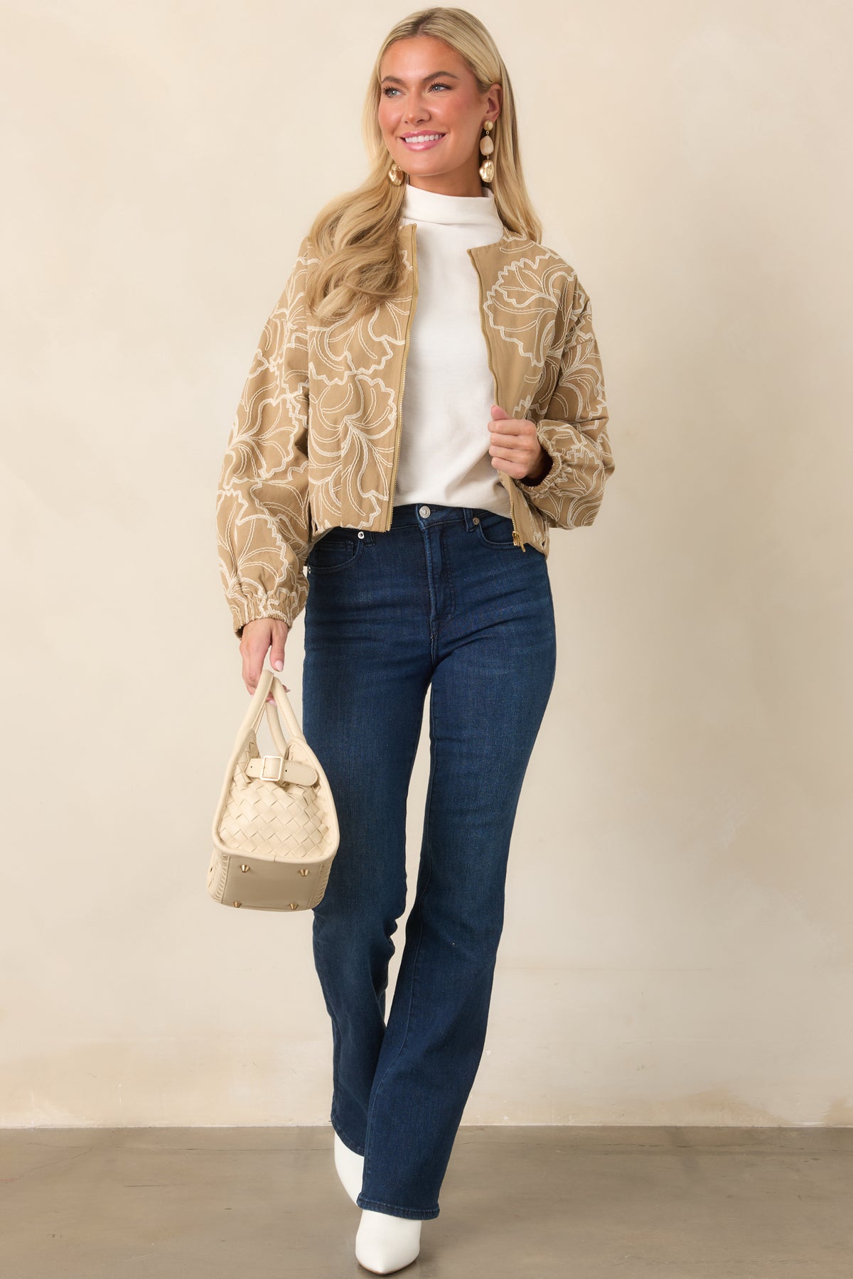 Soft cotton jacket with an embroidered floral design, front zip closure, and slightly cropped silhouette.