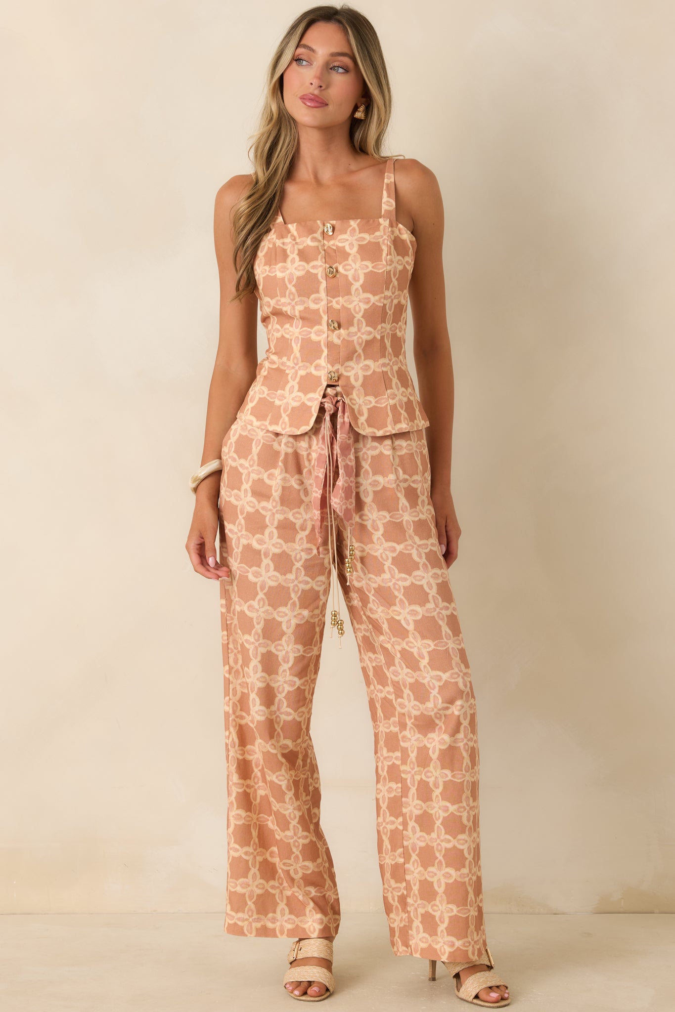 Tan and ivory printed tailored top with a square neckline, decorative gold-tone button front, and a flattering structured silhouette.