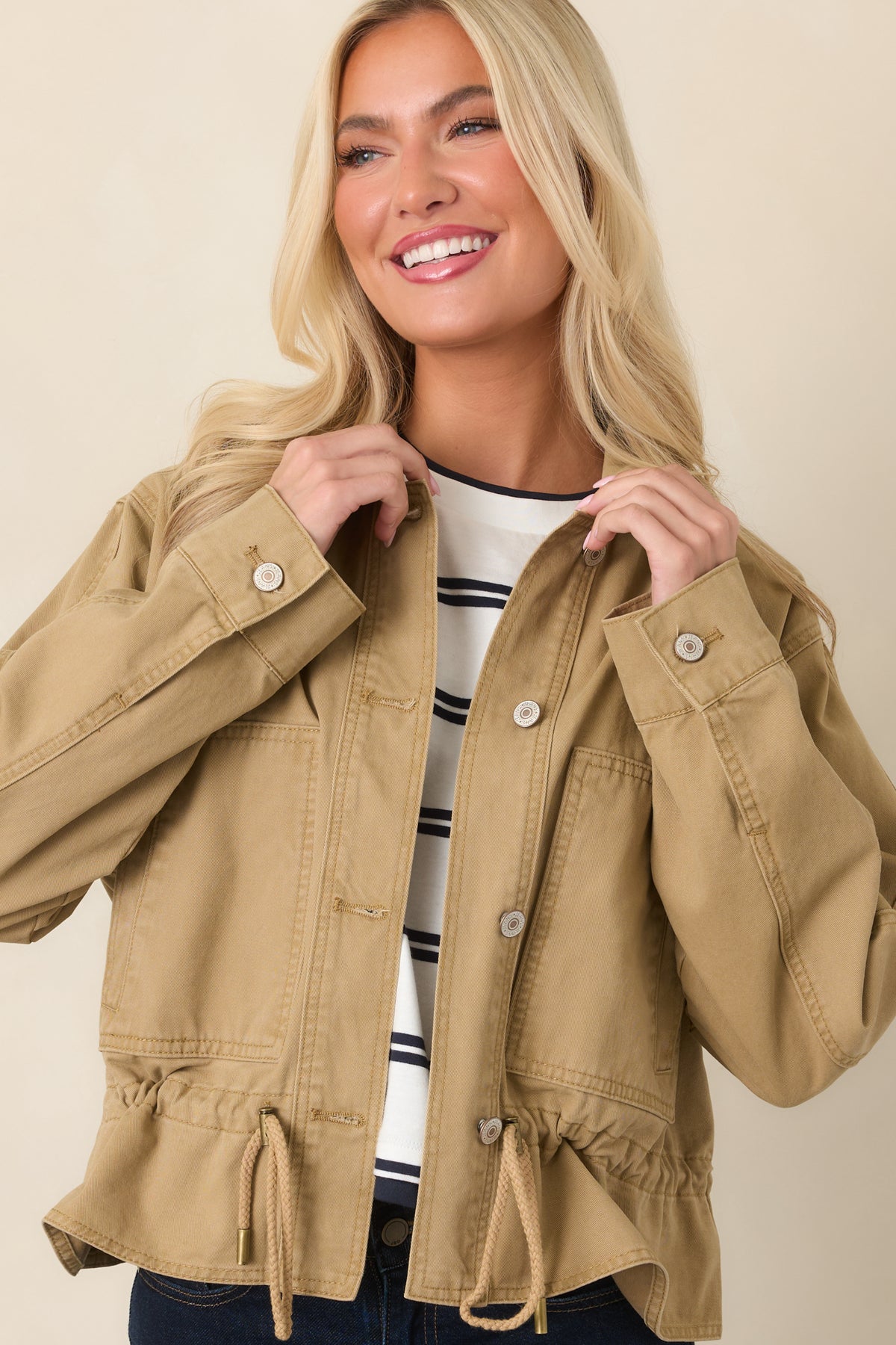 Tan jacket highlighting the collared neckline, button-front closure, and sturdy woven construction.