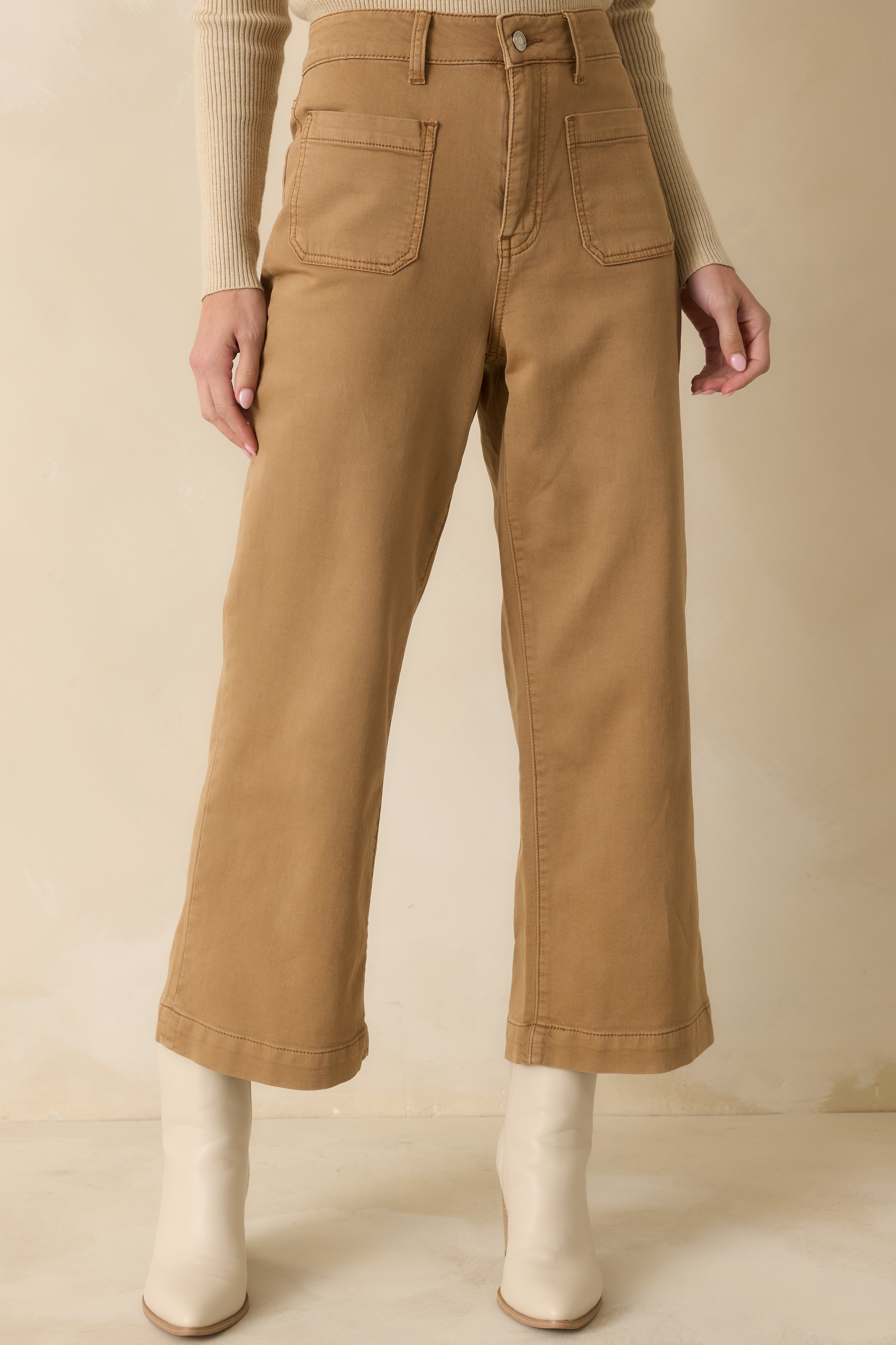 Close front view focusing on the waistband, button and zipper closure, and functional front patch pockets.