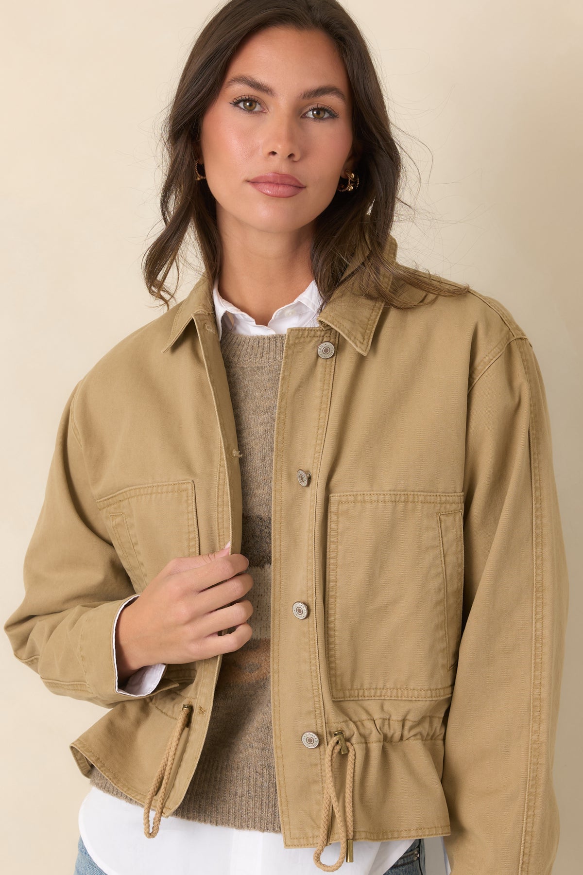 Adjustable drawcord hem creates a customizable shape on this relaxed tan utility jacket.