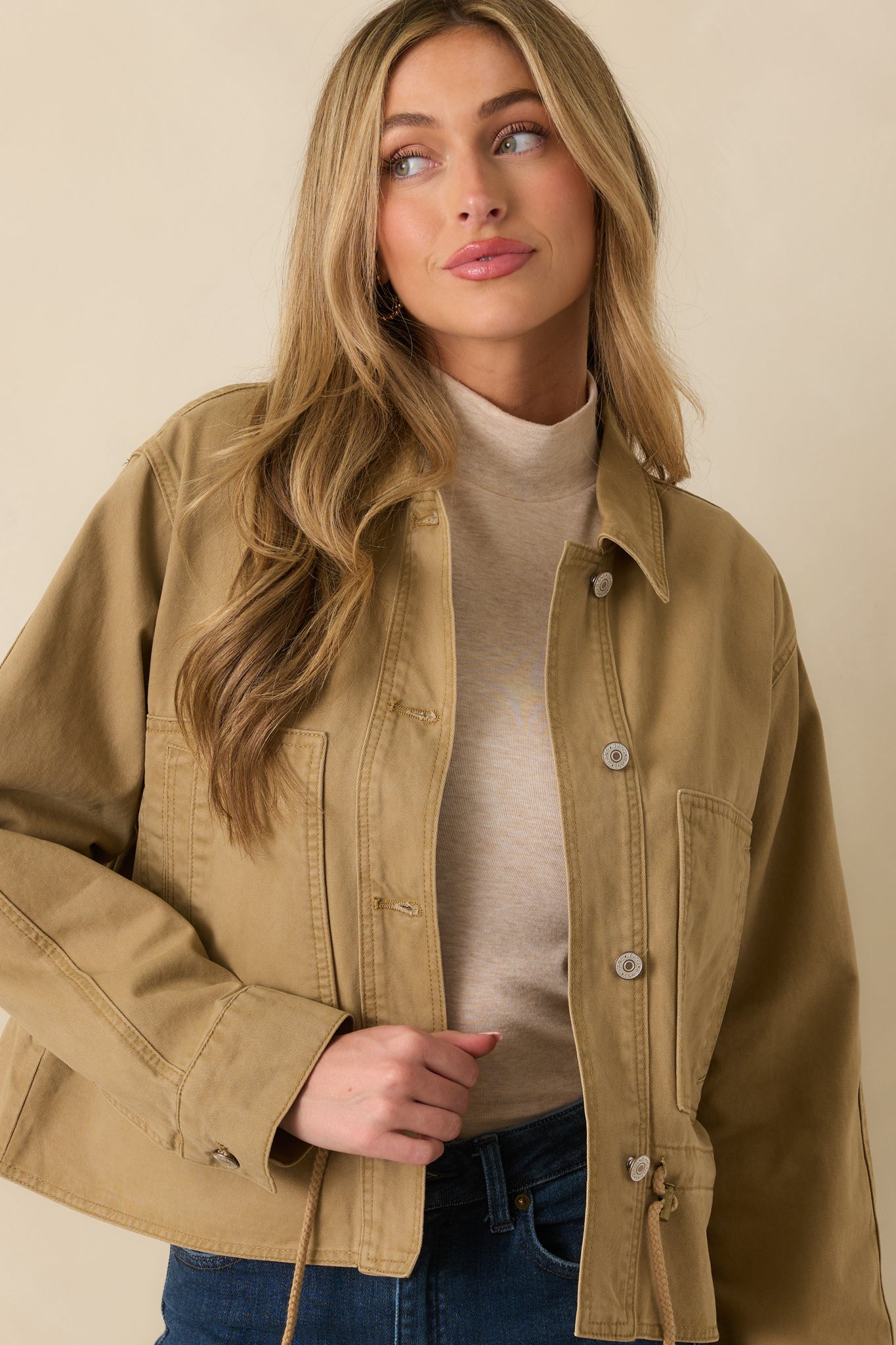 Tan utility jacket focusing on the buttoned collar and smooth woven texture.