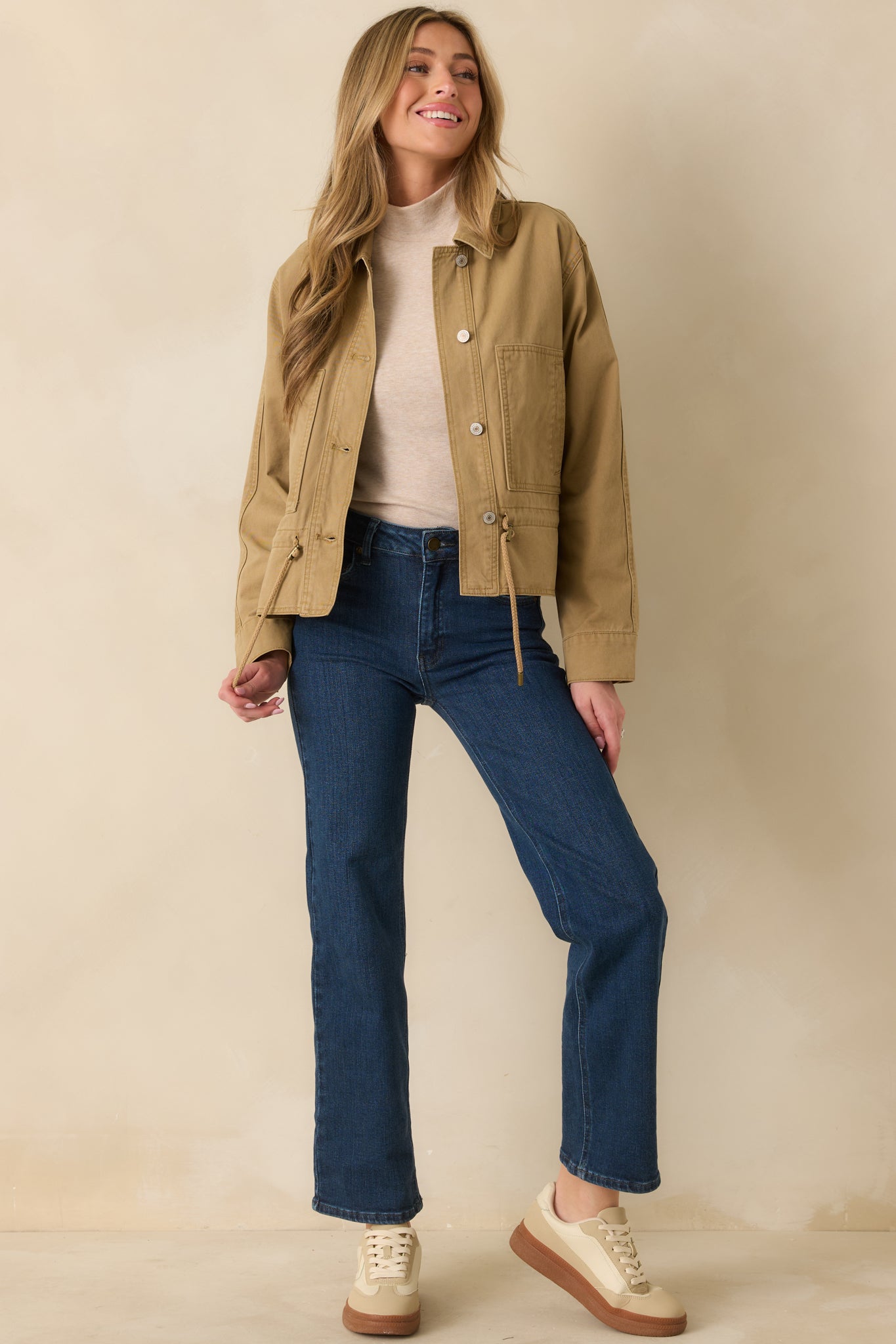 Tan utility jacket highlighting the front button closures and large patch pockets.