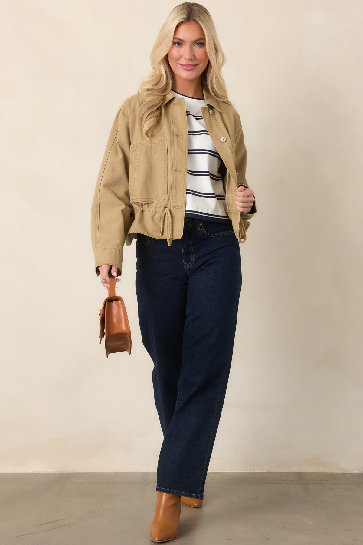 Tan utility jacket showcasing its sturdy woven fabric, front button closures, and adjustable hem.