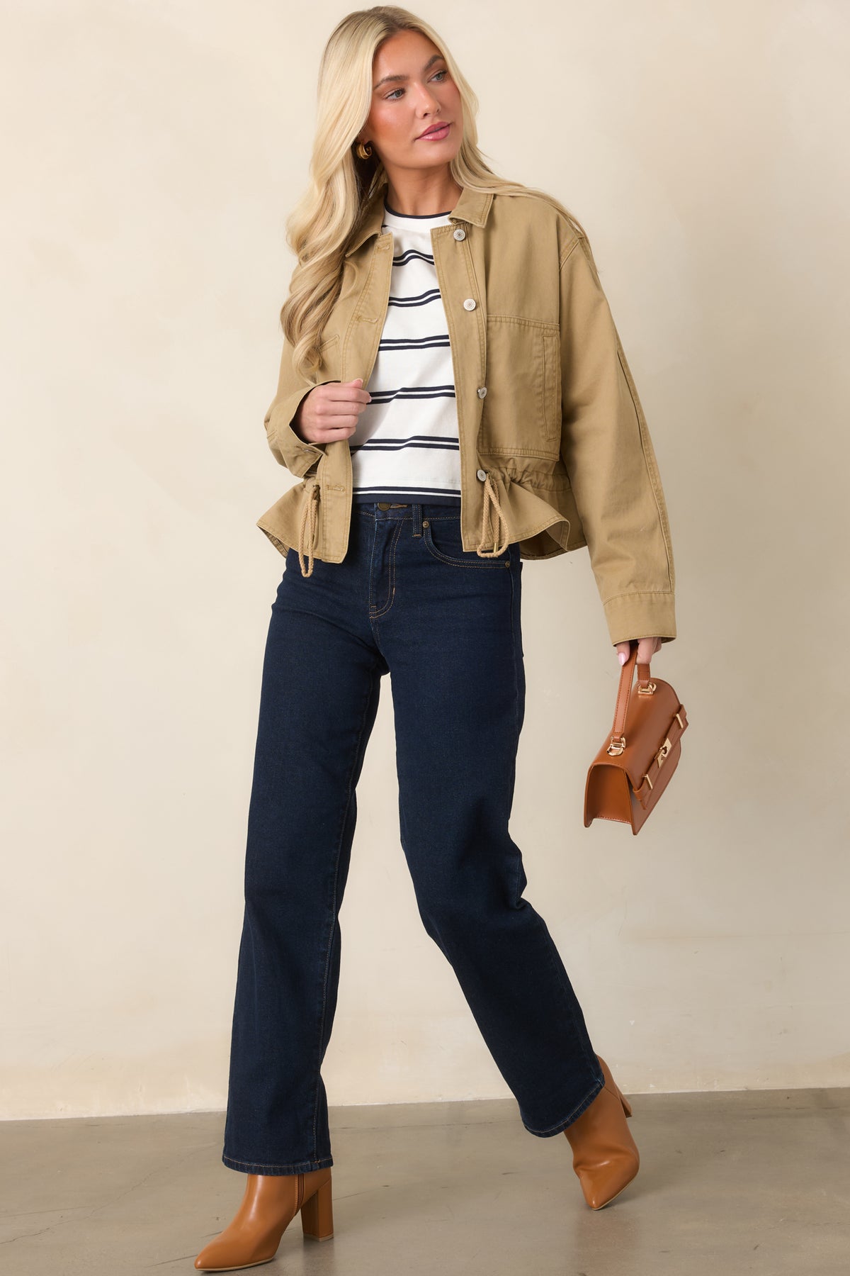 Tan utility-style jacket showcasing its relaxed shape, collared neckline, front buttons, and drawcord hem.