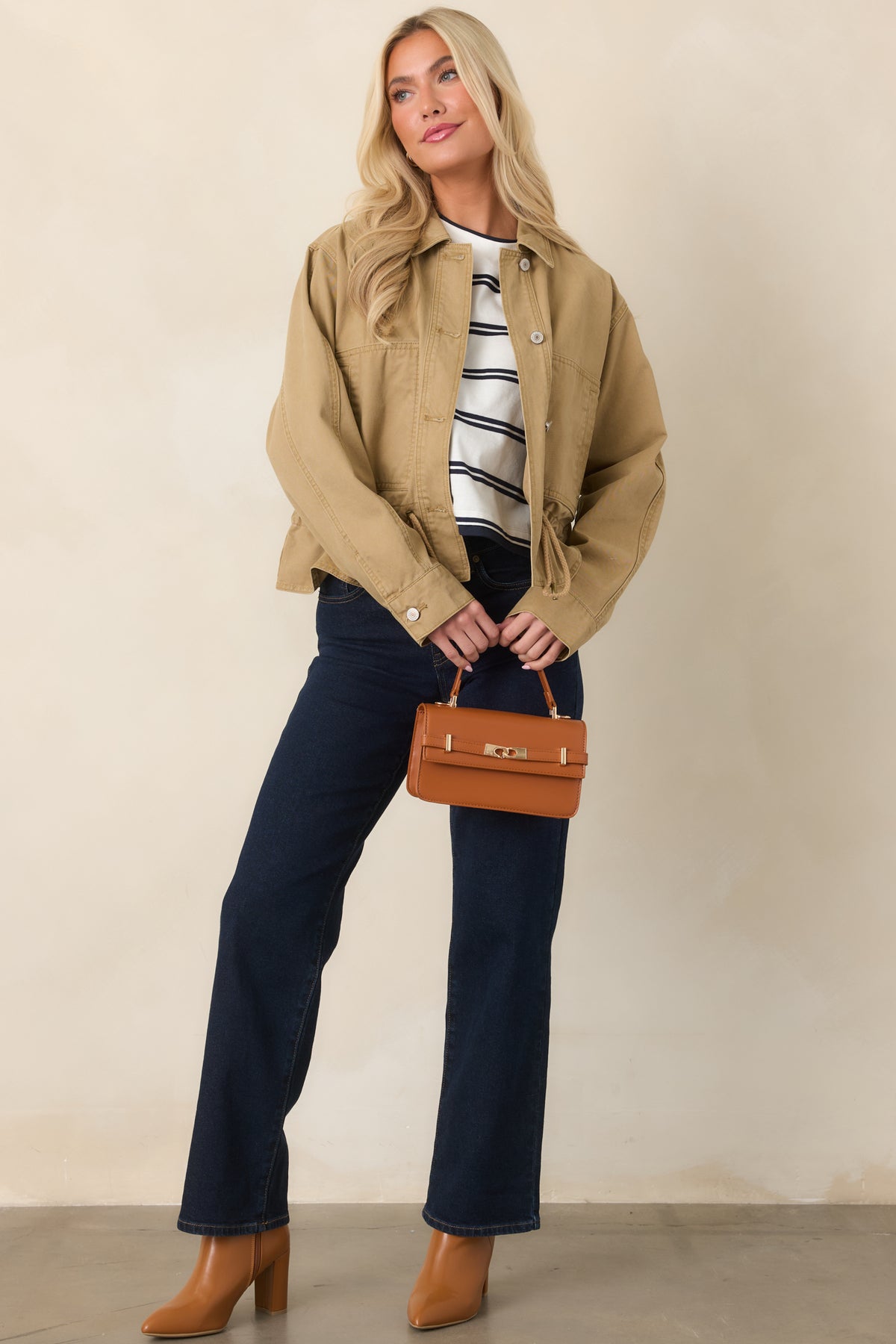 Tan woven jacket with long sleeves, button cuffs, large patch pockets, and adjustable drawcord hem.
