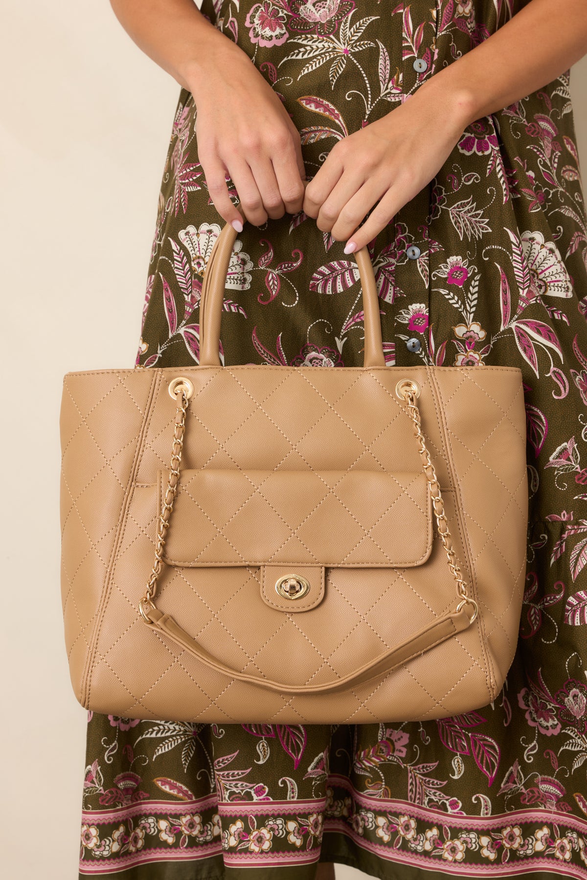 Tan quilted tote bag with gold chain detailing, top handles and front pocket