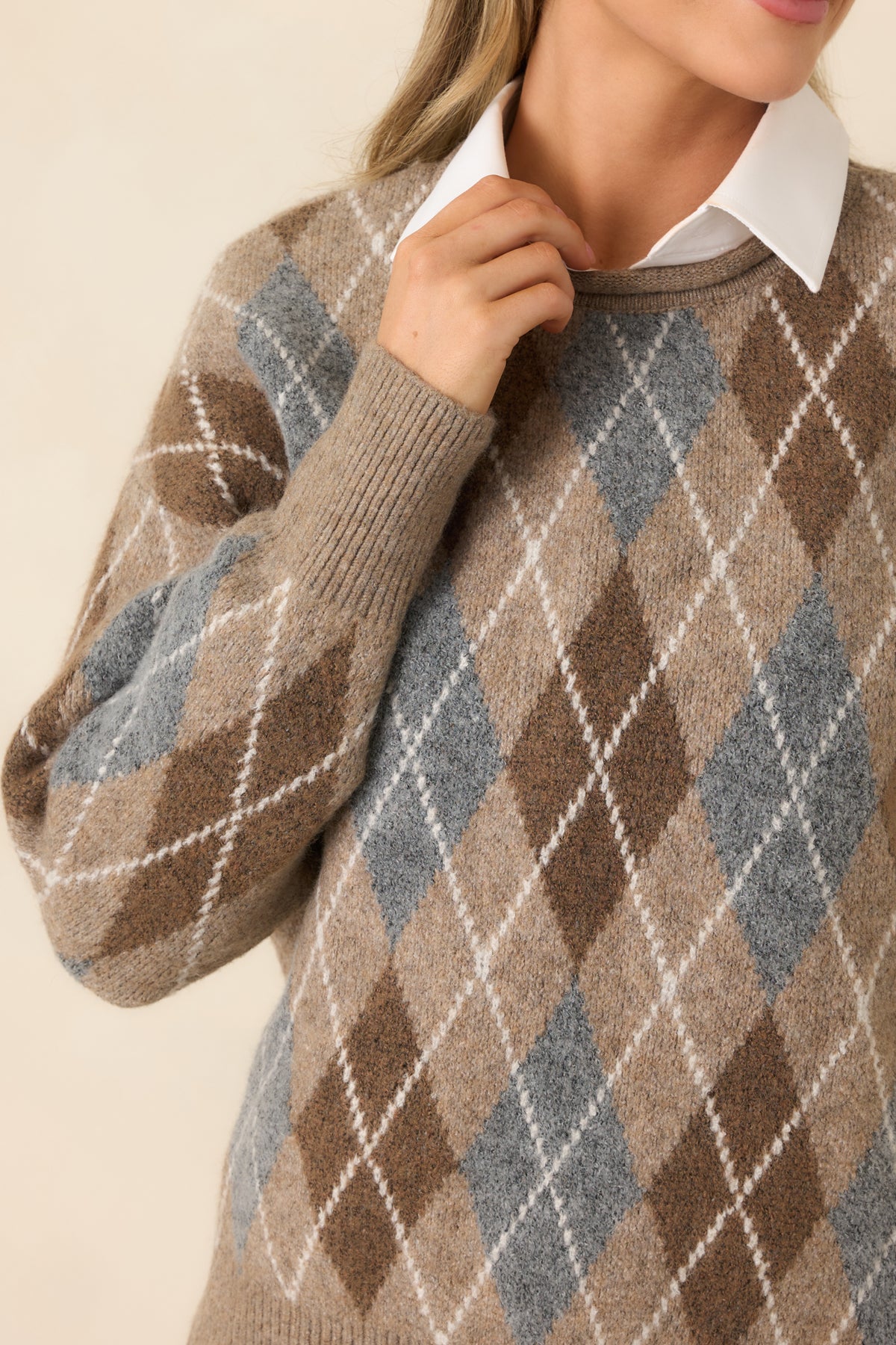 Textured taupe knit highlights the raised cream argyle lines and rolled-edge neckline stitching.