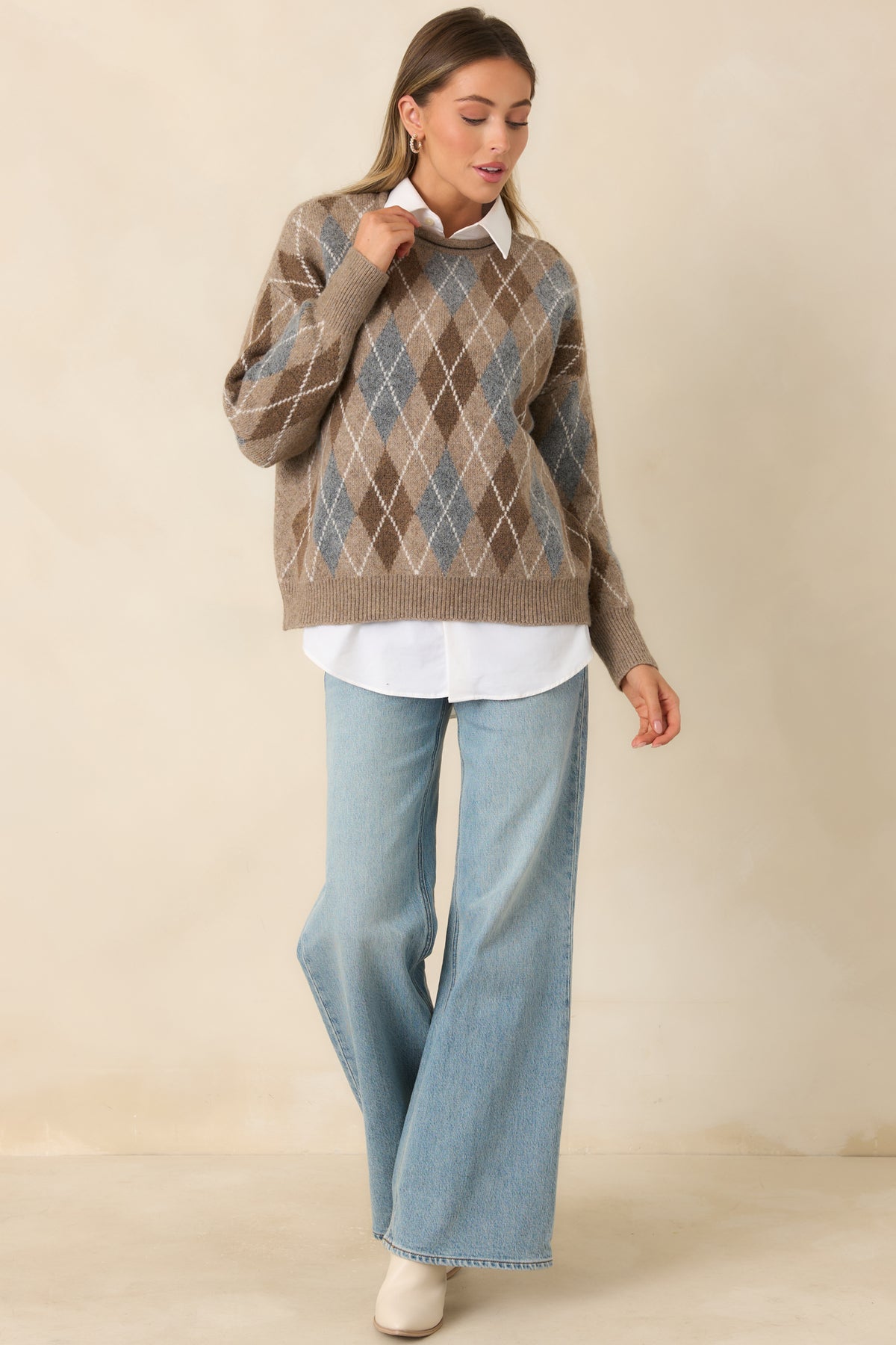 Taupe argyle knit pullover with cream diagonal lines across the front and long sleeves, finished with ribbed cuffs and hem.