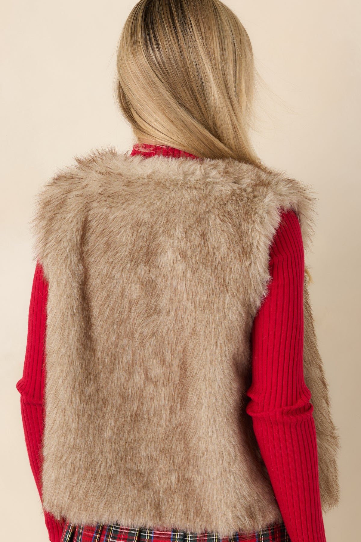 Rear view of the taupe and beige faux fur vest showing its sleeveless shape and straight hip-length hem.
