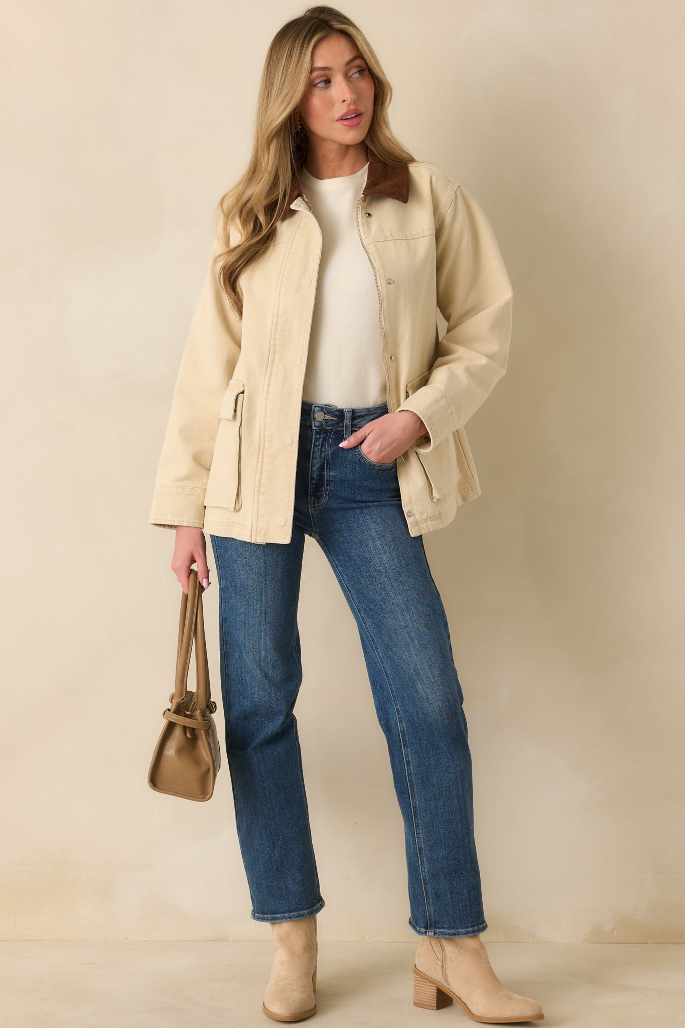 Taupe canvas jacket showing its relaxed straight shape with a clean zip-and-snap front.