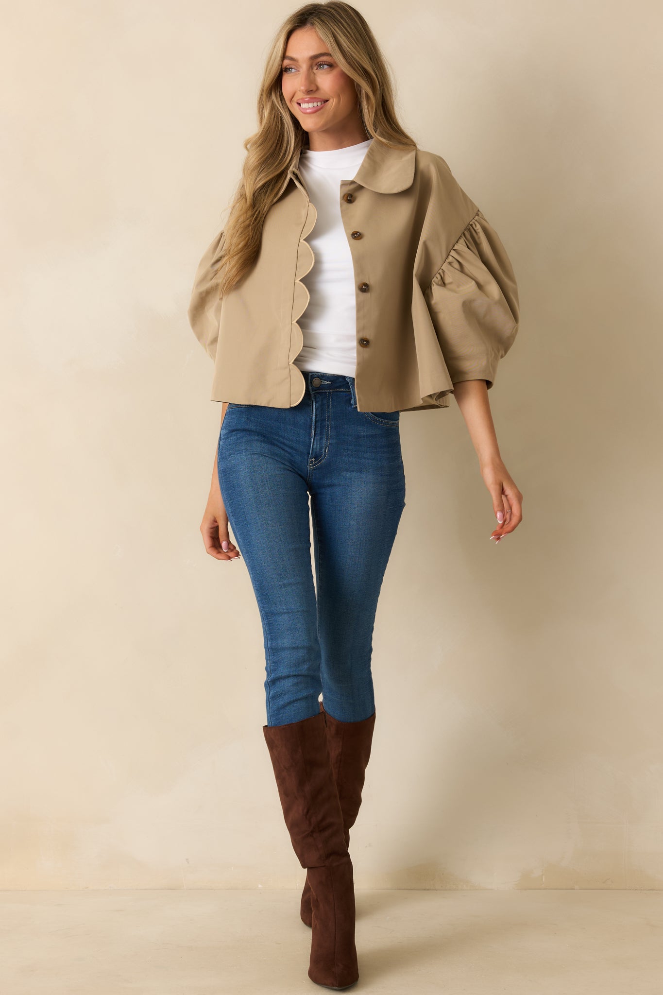 Front view of cropped taupe jacket featuring rounded collar and gathered shoulders.