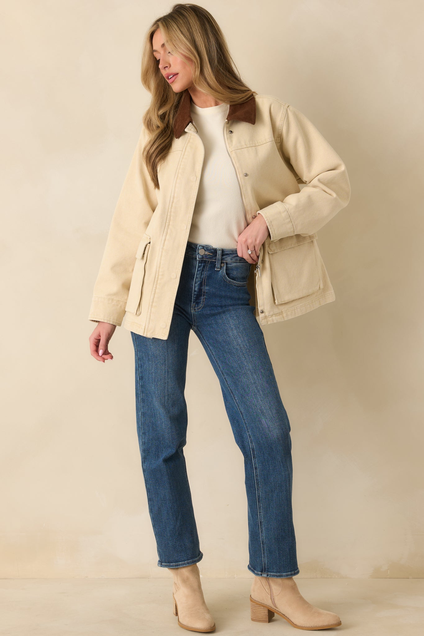 Taupe jacket displaying flap pockets, button-cuff sleeves, and a subtly shaped waist.
