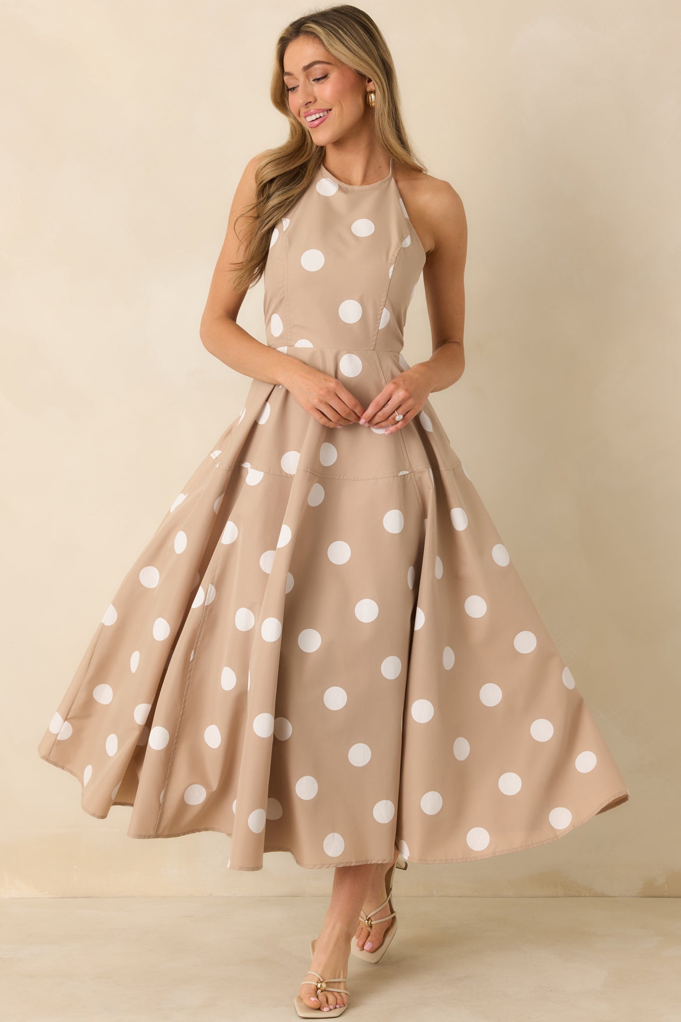 Taupe maxi dress with a halter neckline, white polka dot print, and a tiered, flowing skirt.