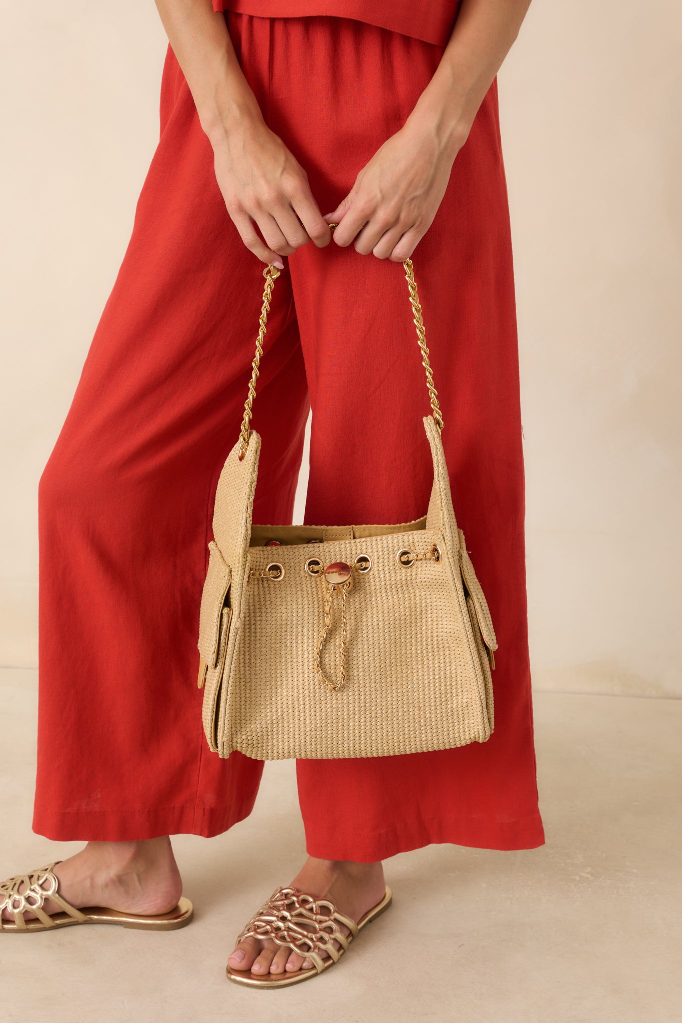 Woven handbag featuring a textured design, gold-tone hardware, adjustable chain shoulder strap, and exterior flap pockets.