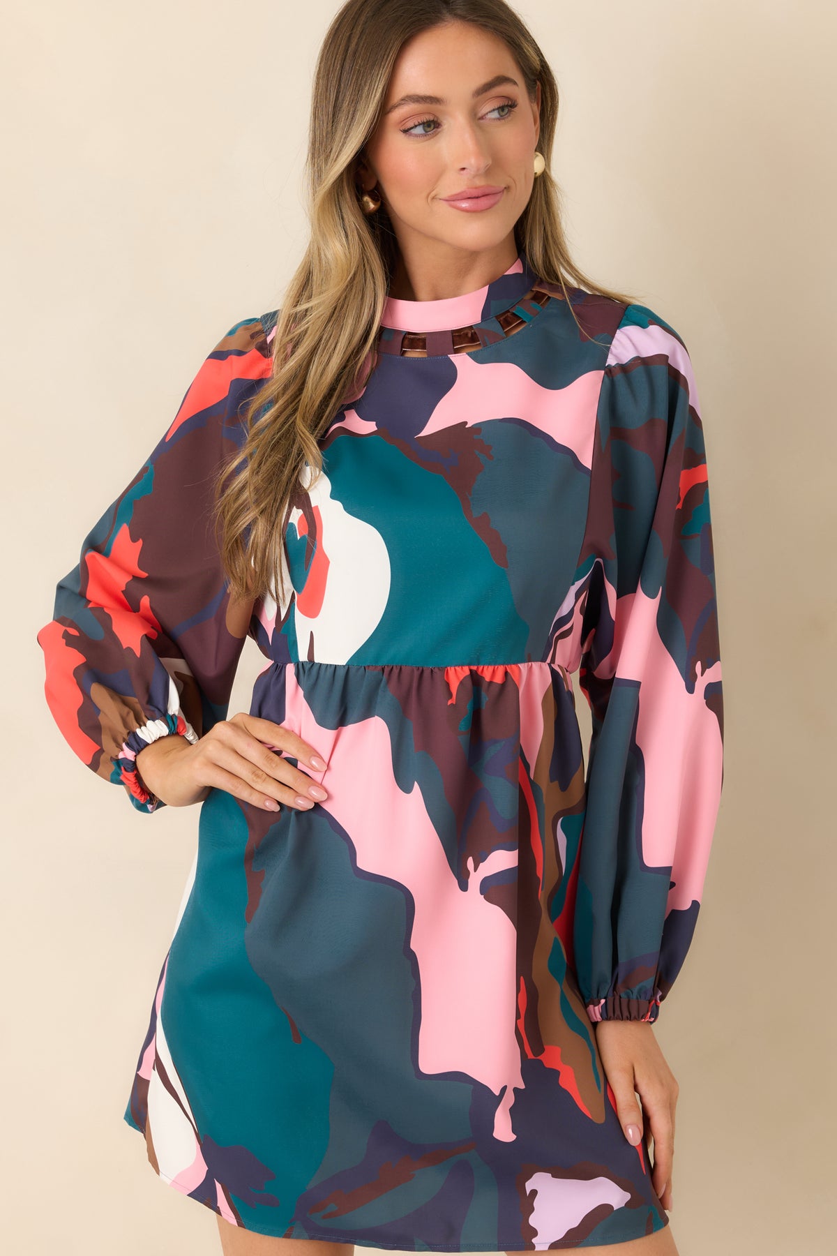 Oversized teal, coral, pink, and purple botanical shapes mix with camel and ivory accents across the mini dress.