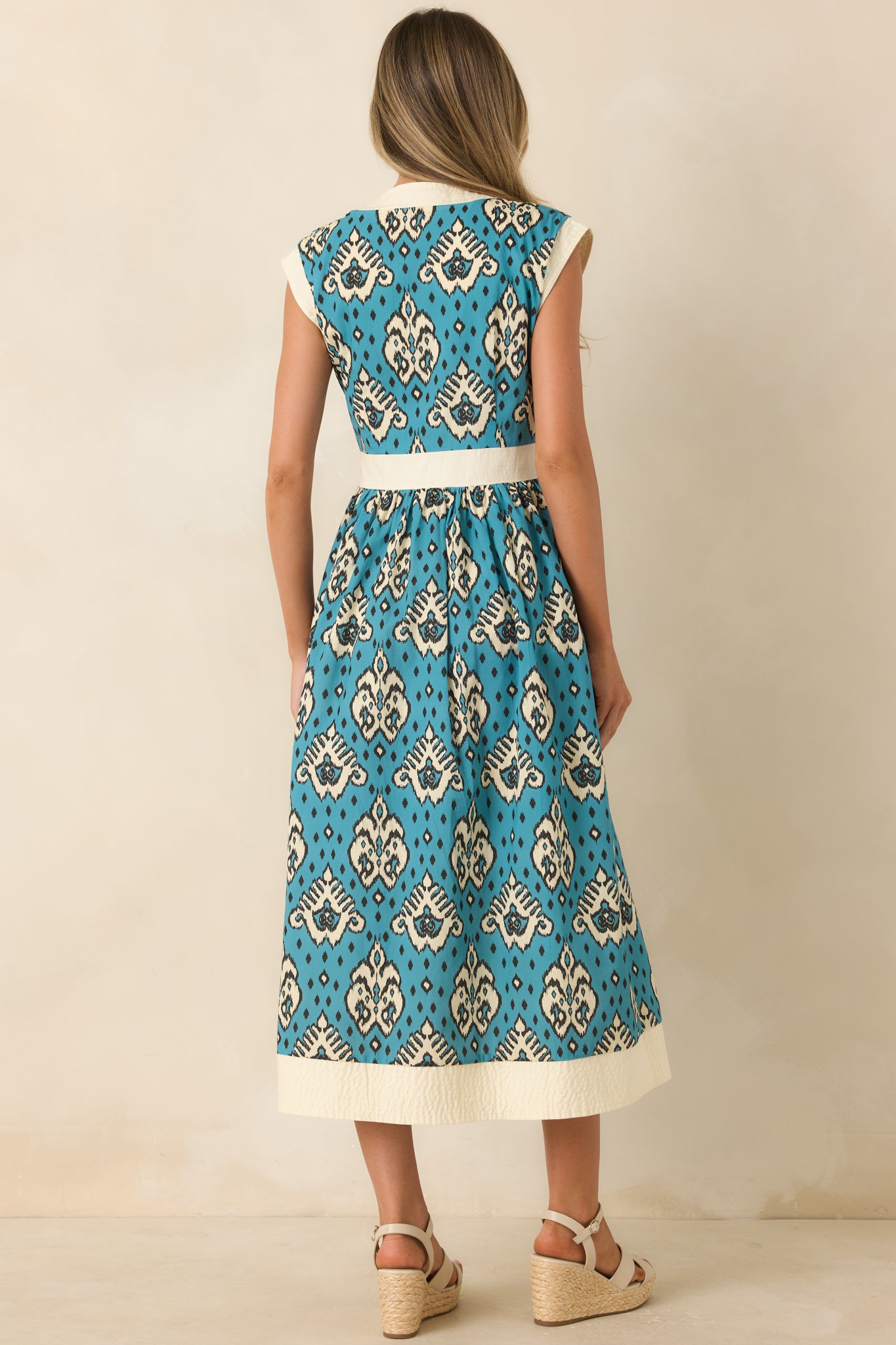 Back view of the teal and ivory cotton midi dress featuring cap sleeves, a defined waist, and flowing A-line skirt.
