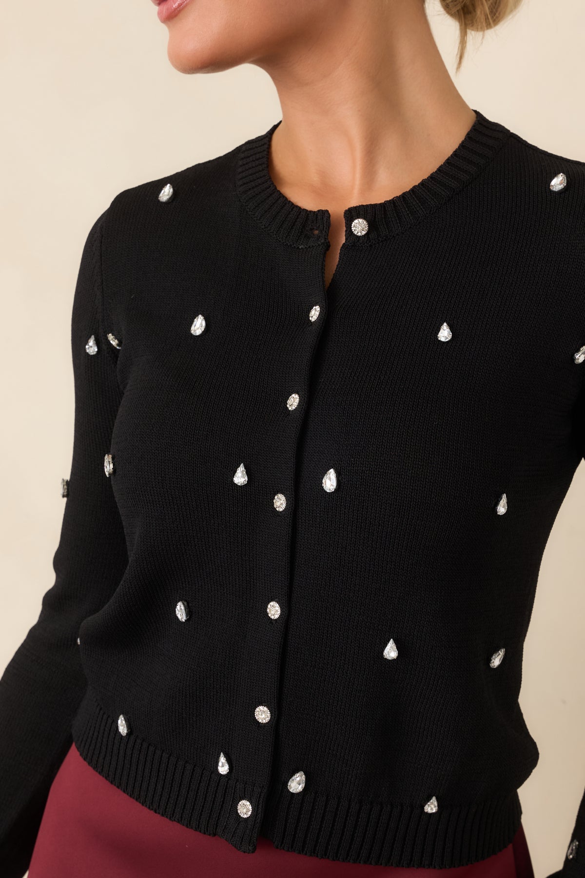 Close-up of the cardigan showing teardrop rhinestones and shimmering round button details.